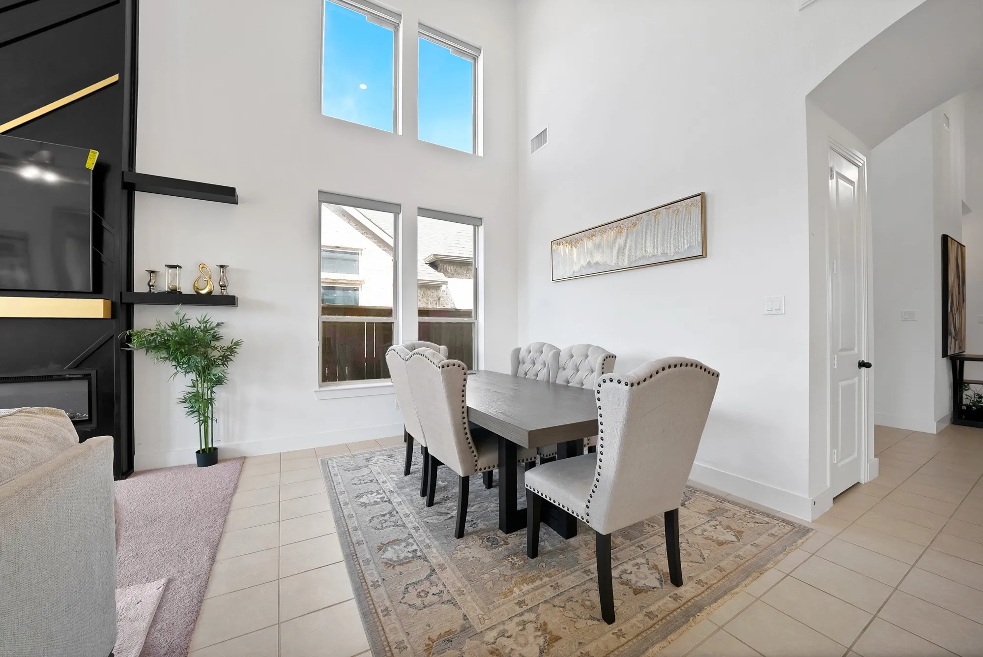 Two-story living area featuring tall windows and a built-in fireplace with shelving