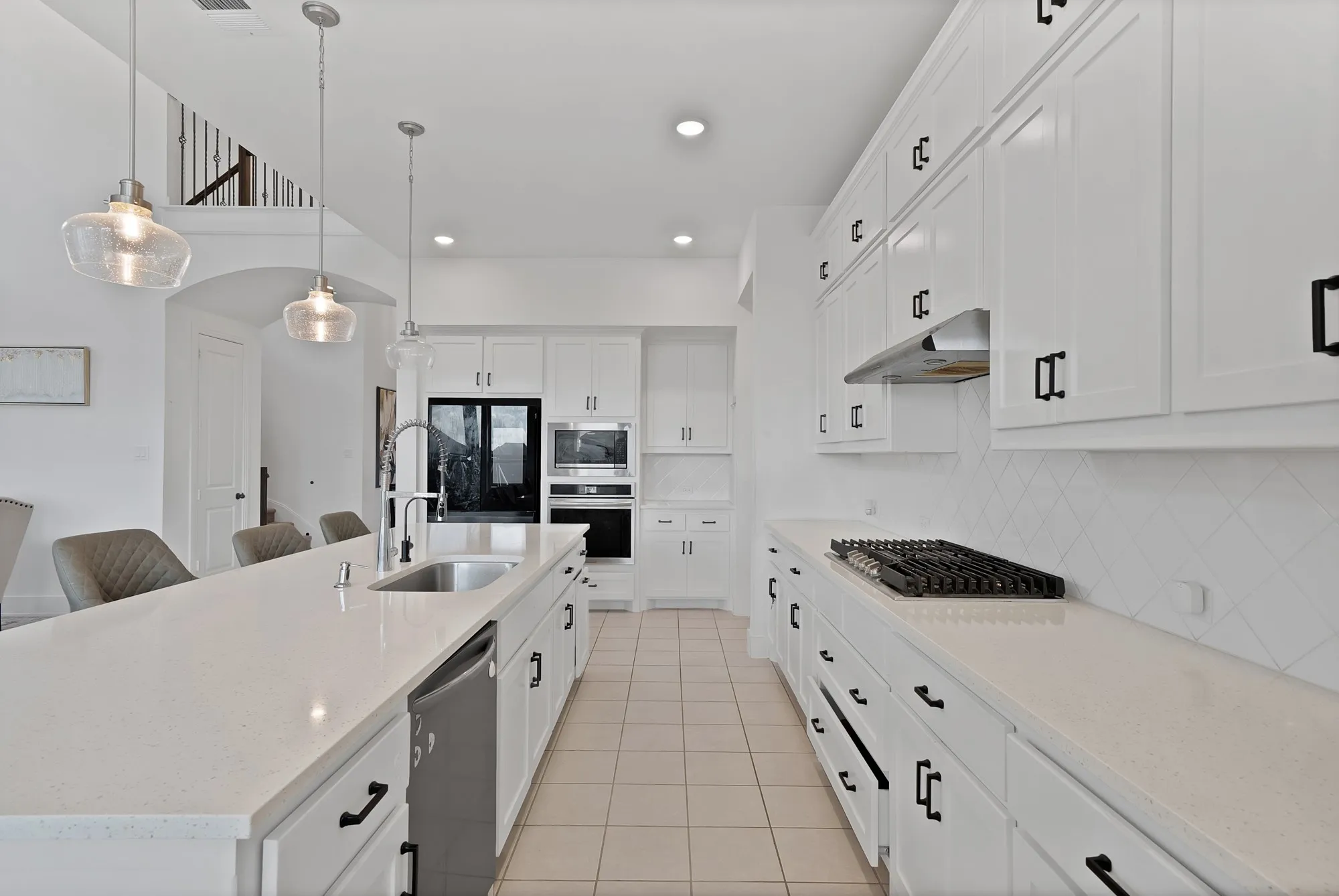 Kitchen featuring white cabinetry, light-toned countertops, a built-in oven, and a gas cooktop