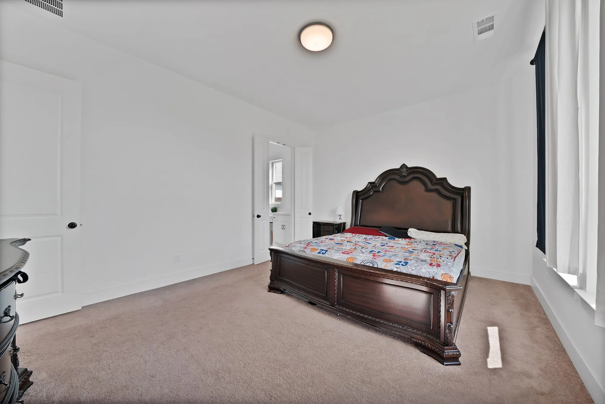 Neutral wall color, wall-to-wall carpeting, recessed ceiling lighting, and a window with white trim