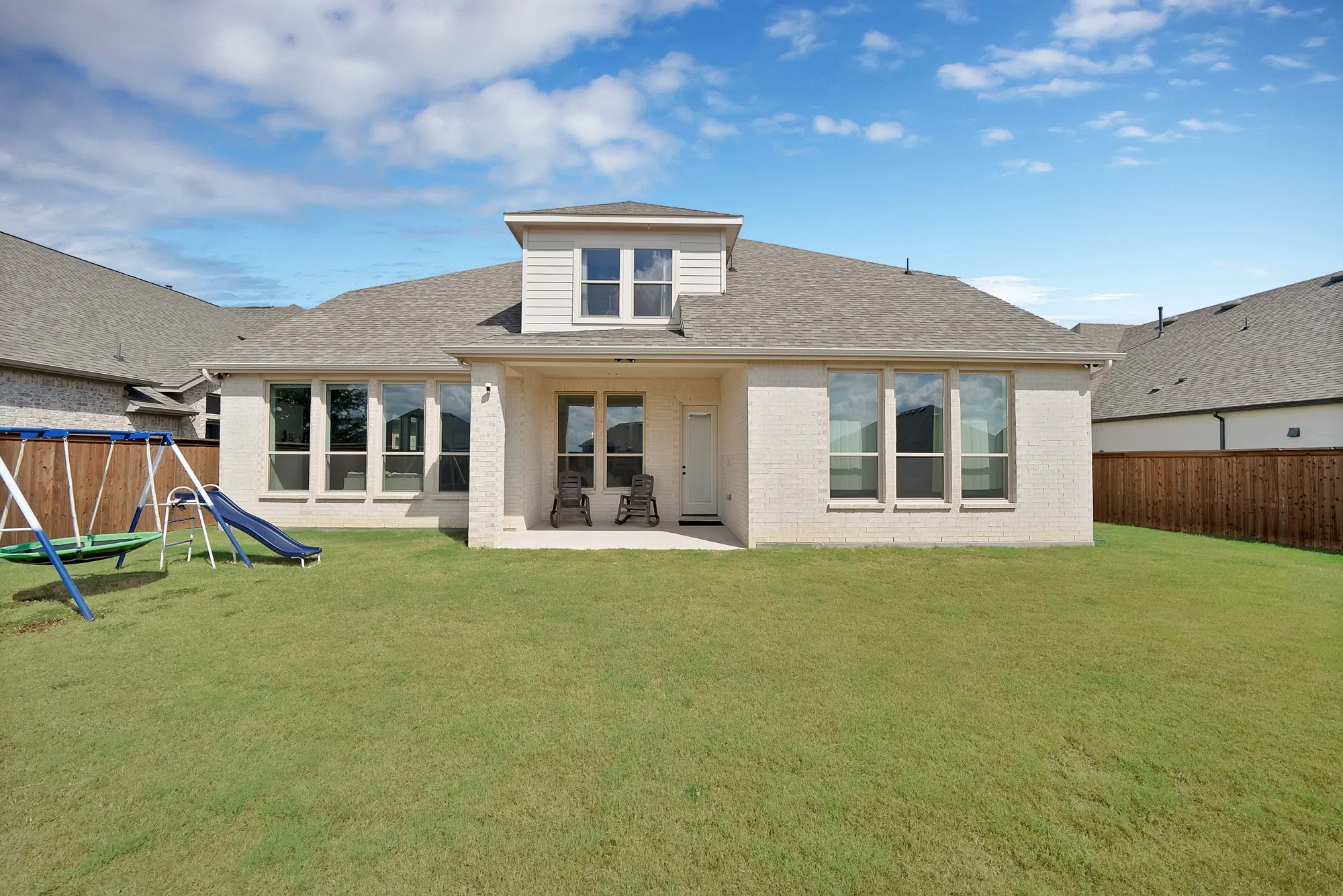 Expansive backyard featuring a manicured lawn, a covered patio, and privacy fencing