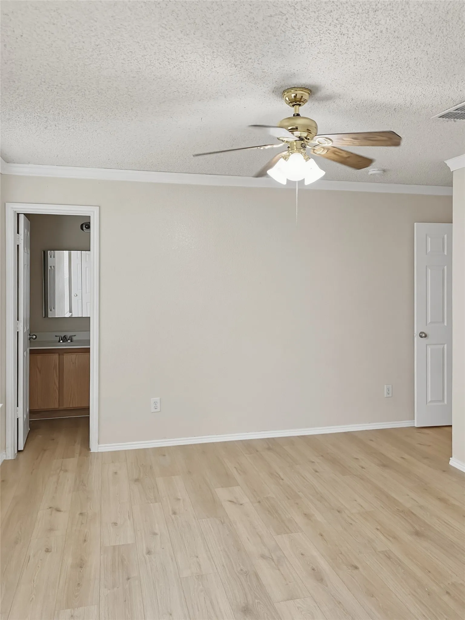 Spacious primary living area featuring wood-finish plank flooring, neutral walls, and abundant natural light