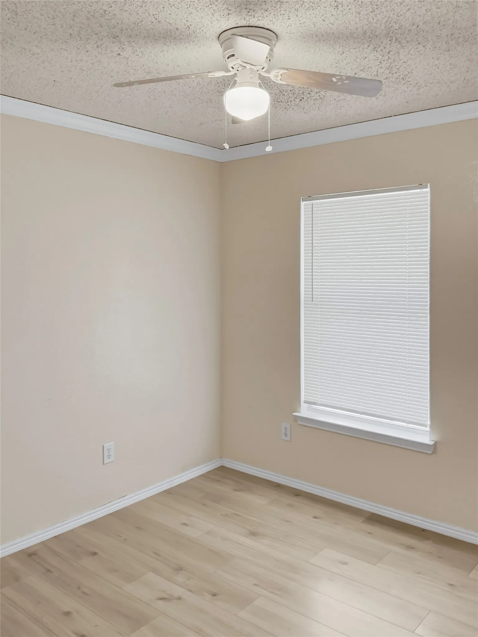 Wood-finish flooring, white window blinds, and a ceiling fan with integrated lighting