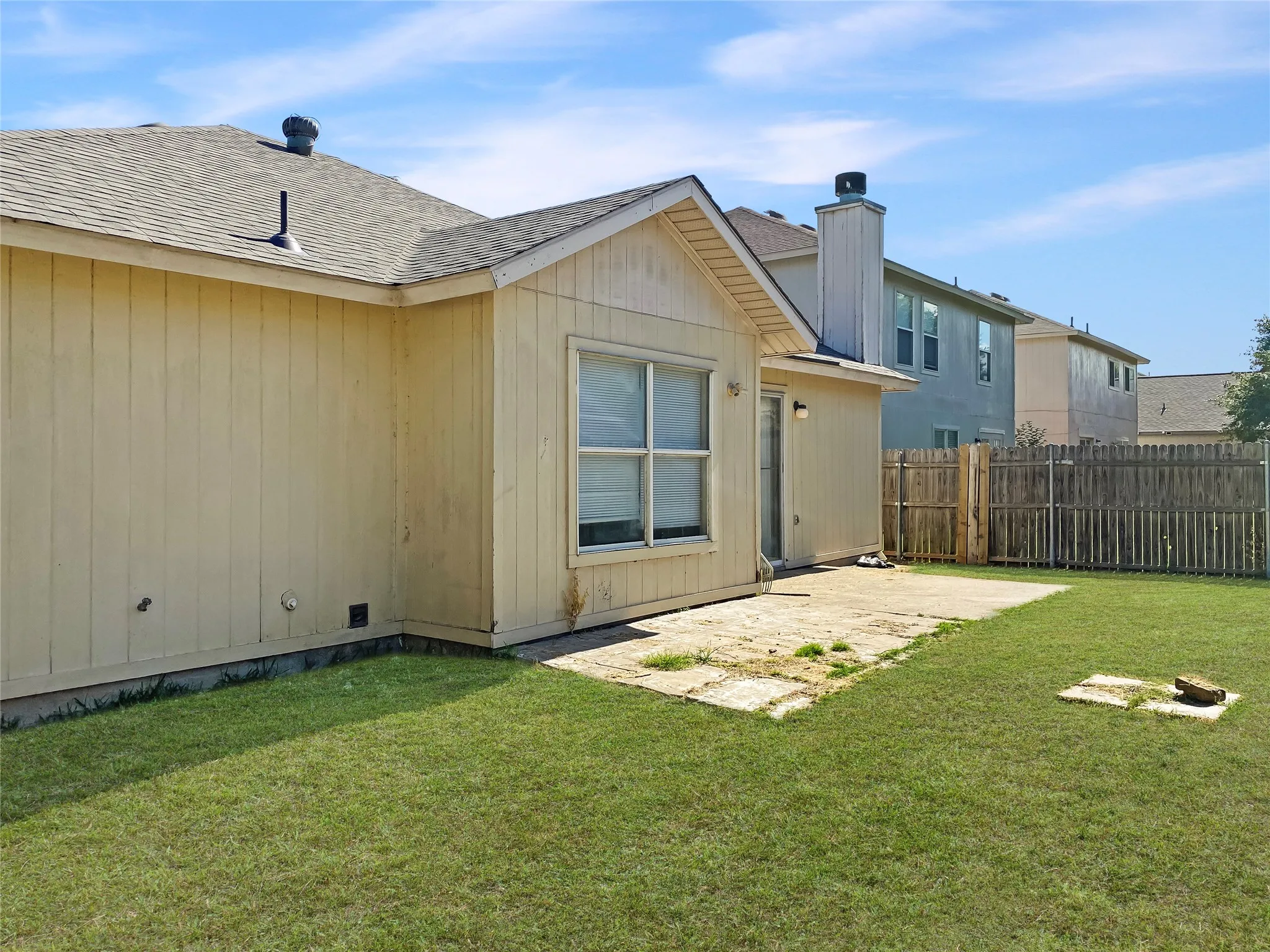 Expansive grass lawn with a concrete patio