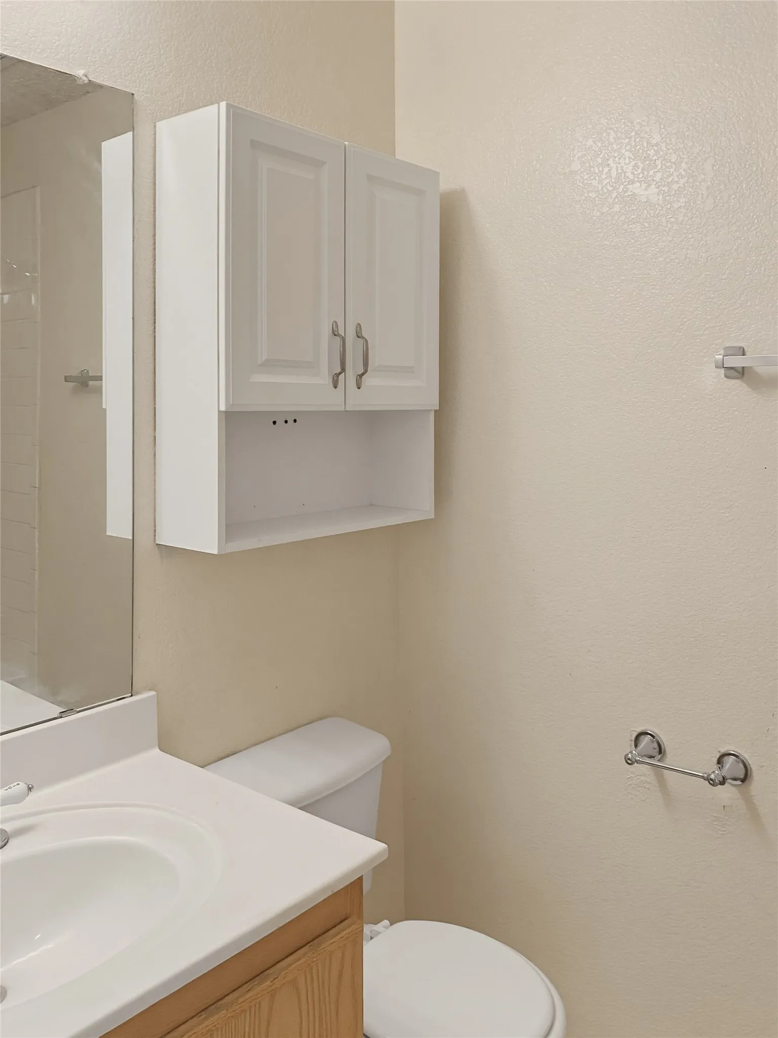 Wood-finish vanity with an integrated white sink and mirror