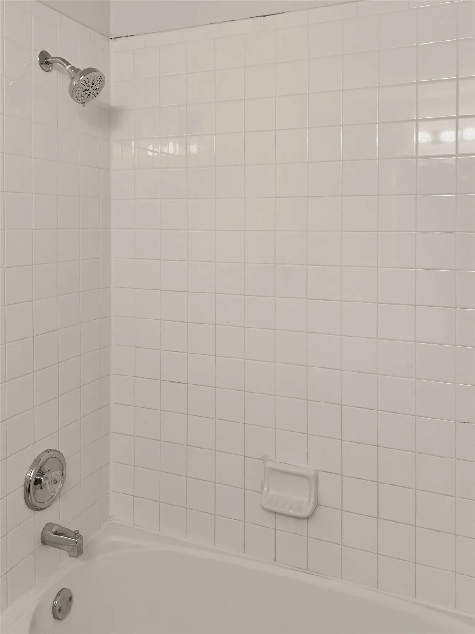 White tiled shower surround with a built-in tub