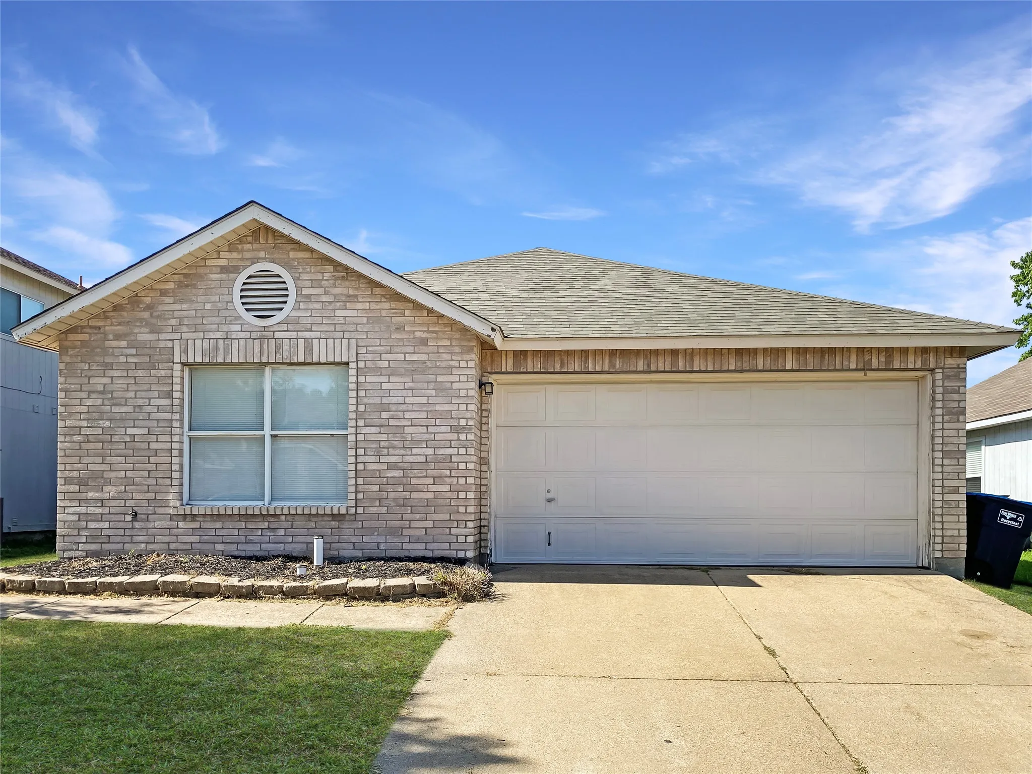 Brick facade, attached garage, shingled roof, front lawn