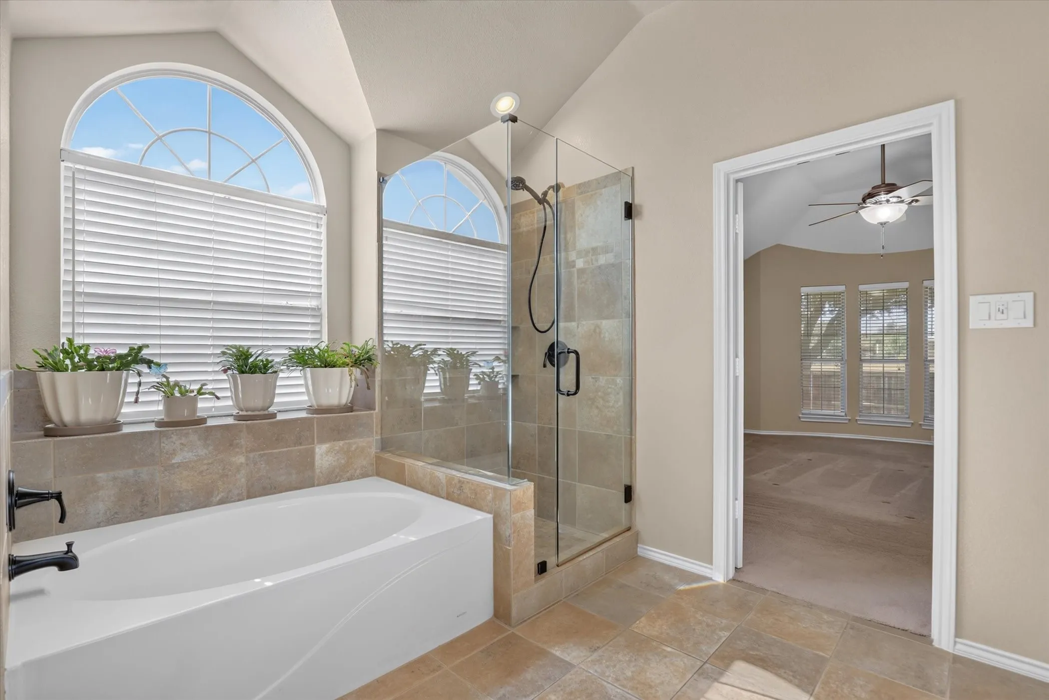 Tiled soaking tub with dark bronze fixtures