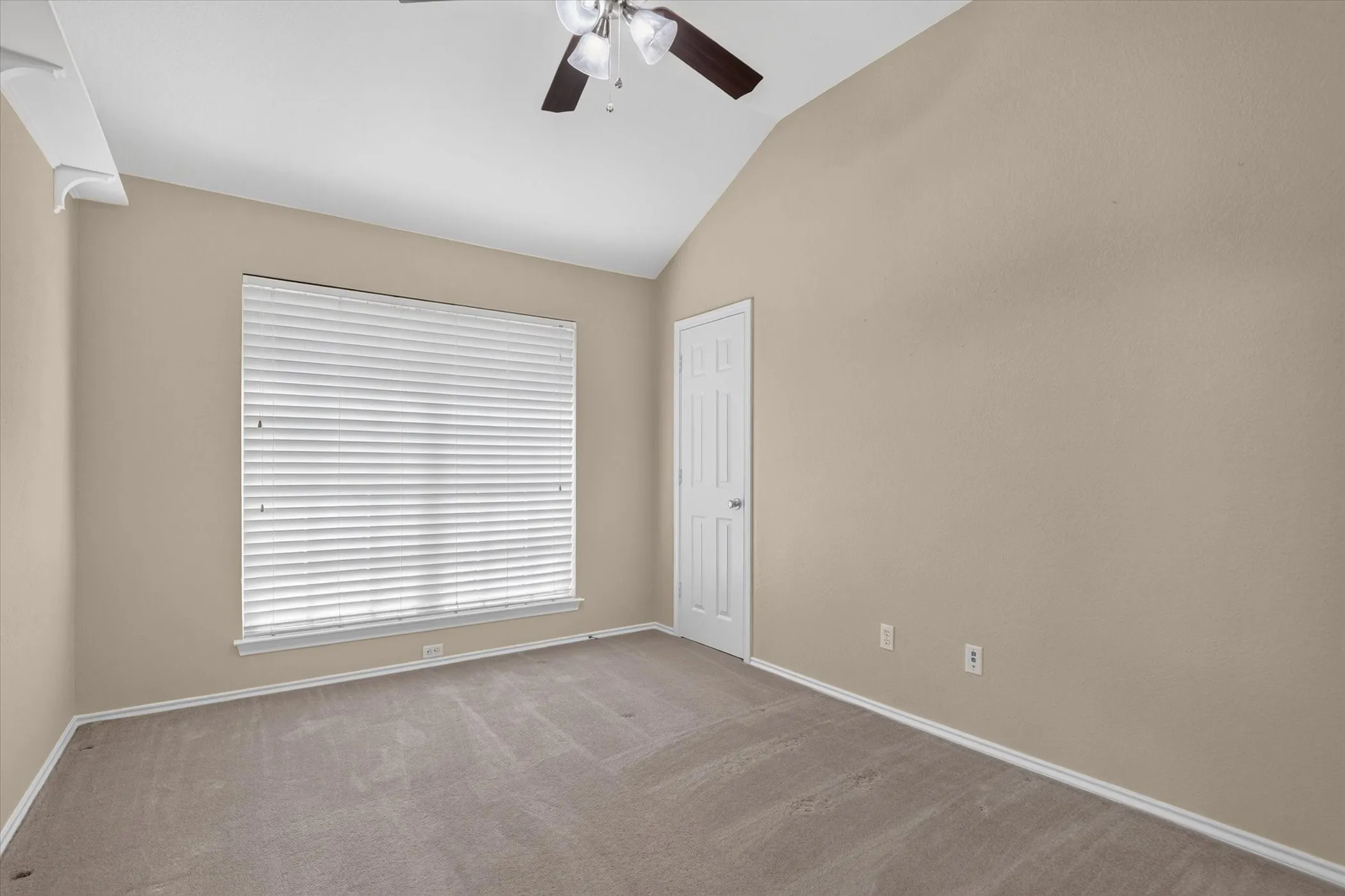 Vaulted ceiling with a ceiling fan, neutral carpet, and a large window with blinds