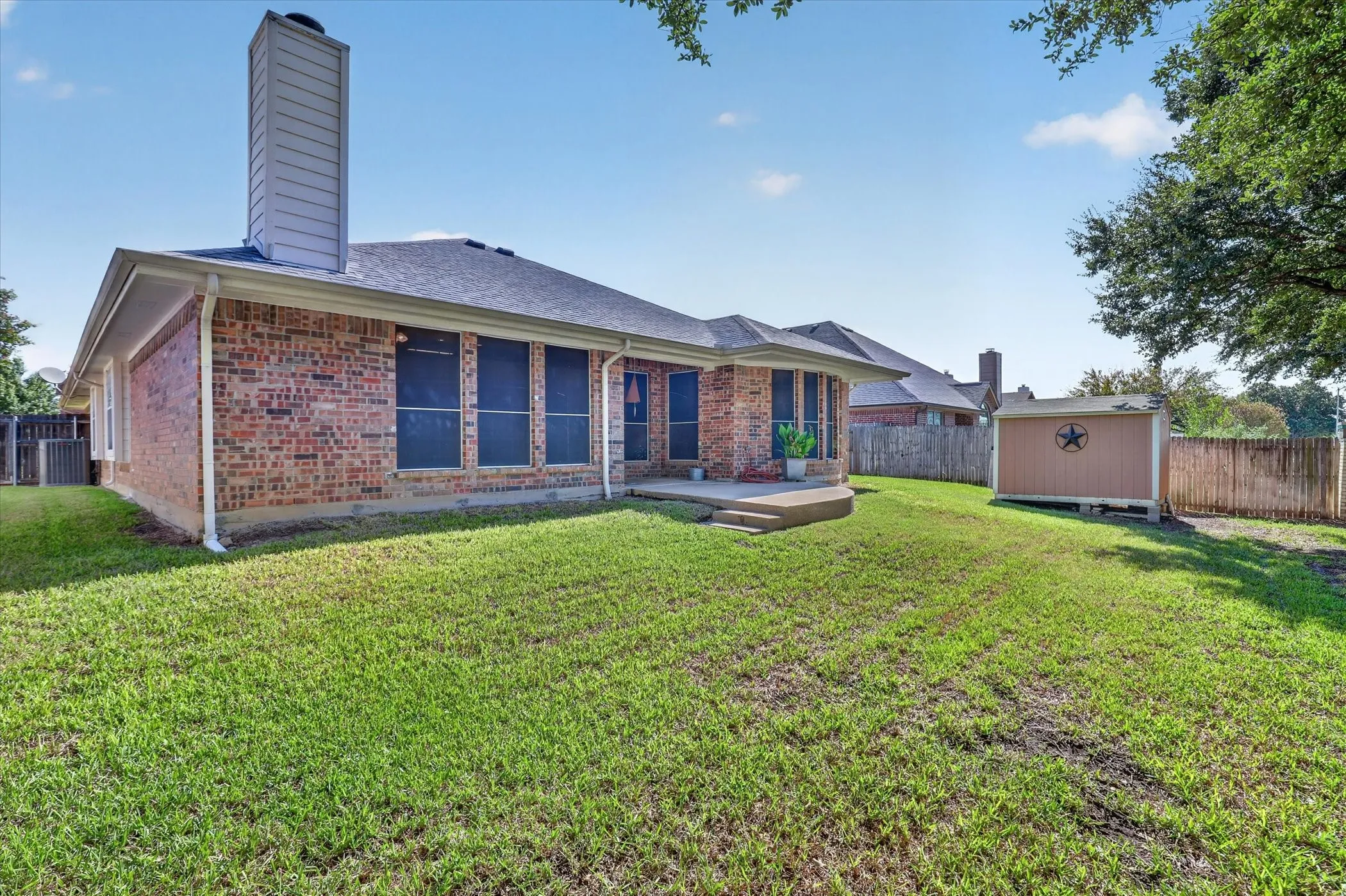 Brick exterior, outdoor patio with concrete steps, and a storage shed
