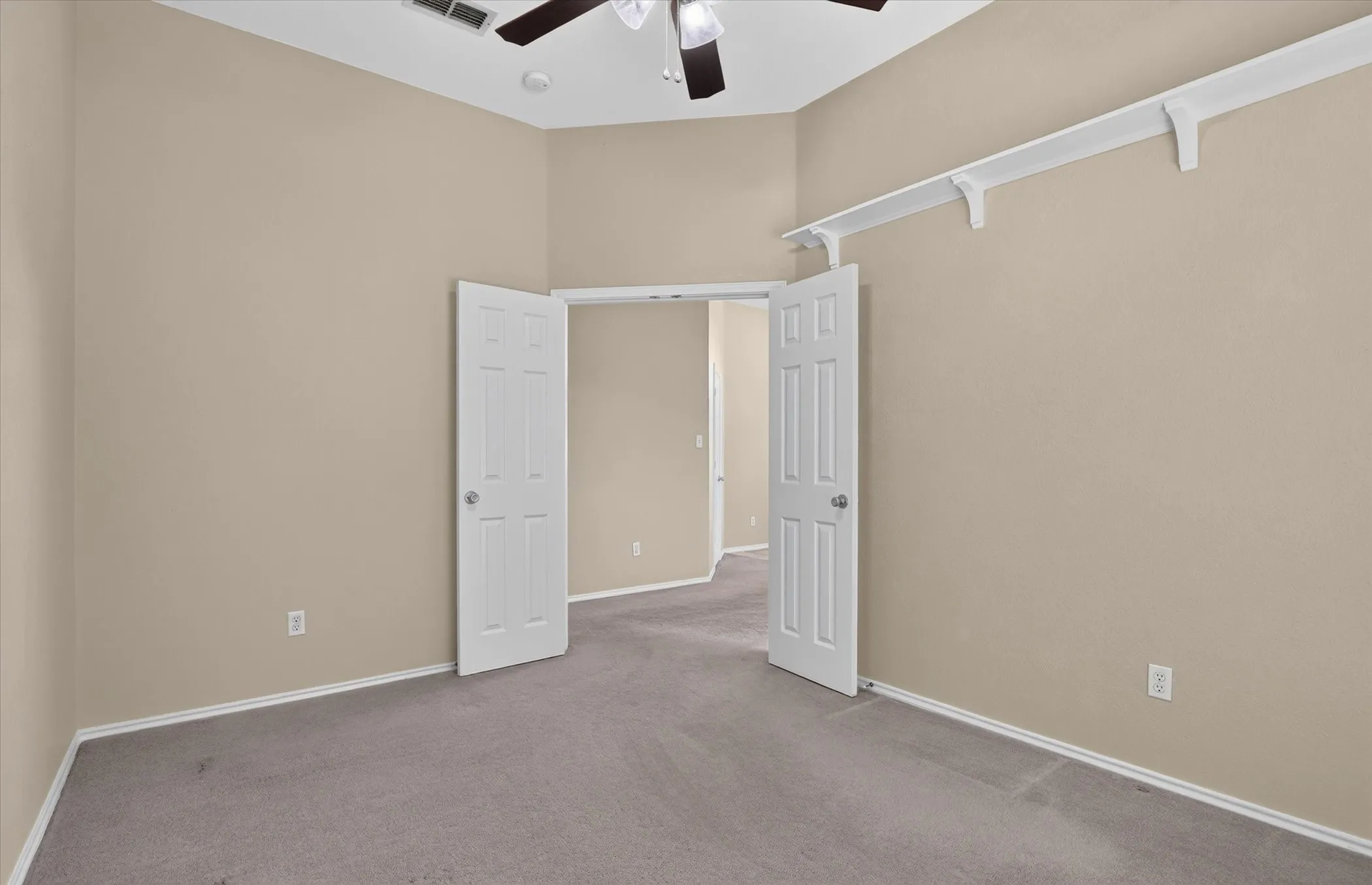 Vaulted ceiling with a ceiling fan, neutral wall paint, and gray carpet flooring