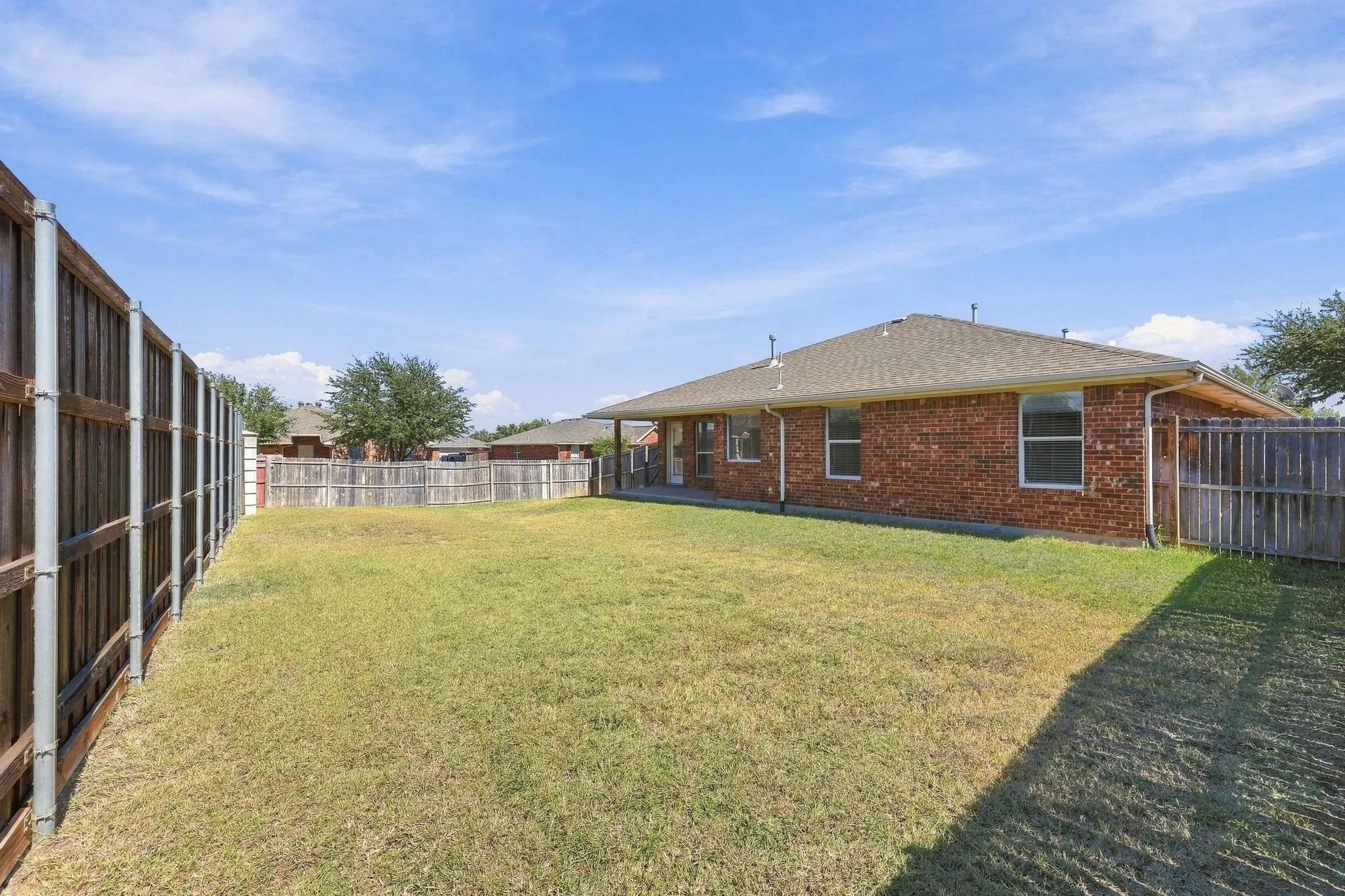Expansive grass lawn with surrounding wood fencing
