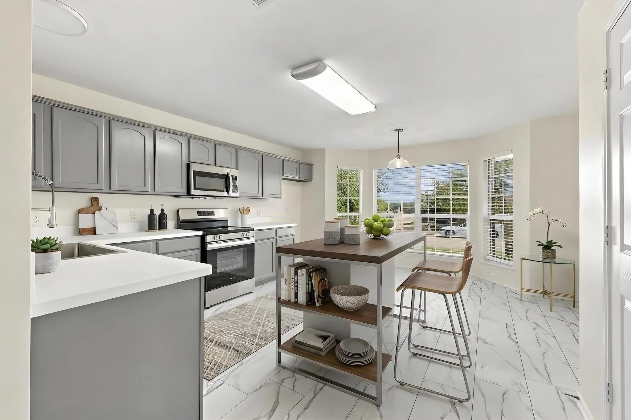 This room has been virtually staged using AI to illustrate its potential countertops, stainless steel appliances, grey cabinetry, white tile flooring, and a central island with open shelving