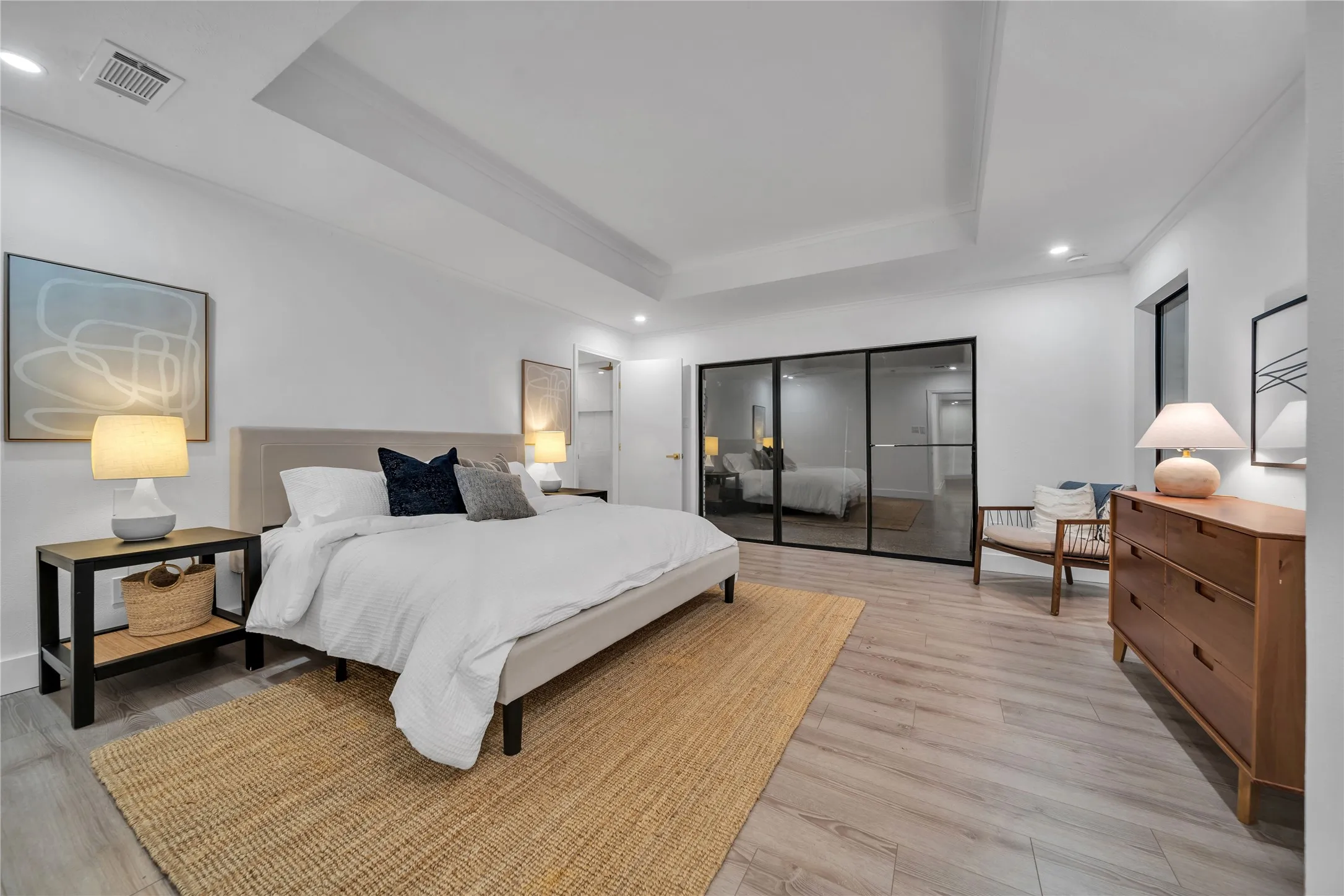 Bedroom featuring a raised ceiling and light hardwood / wood-style floors