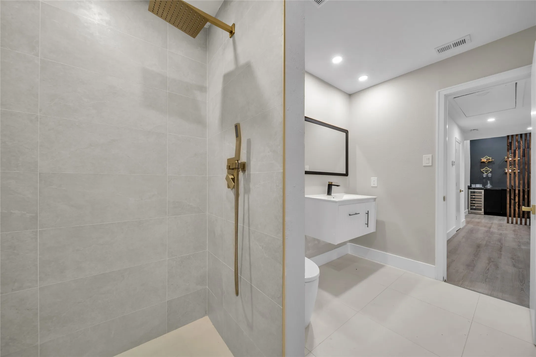 Bathroom with toilet, tile patterned flooring, vanity, and tiled shower