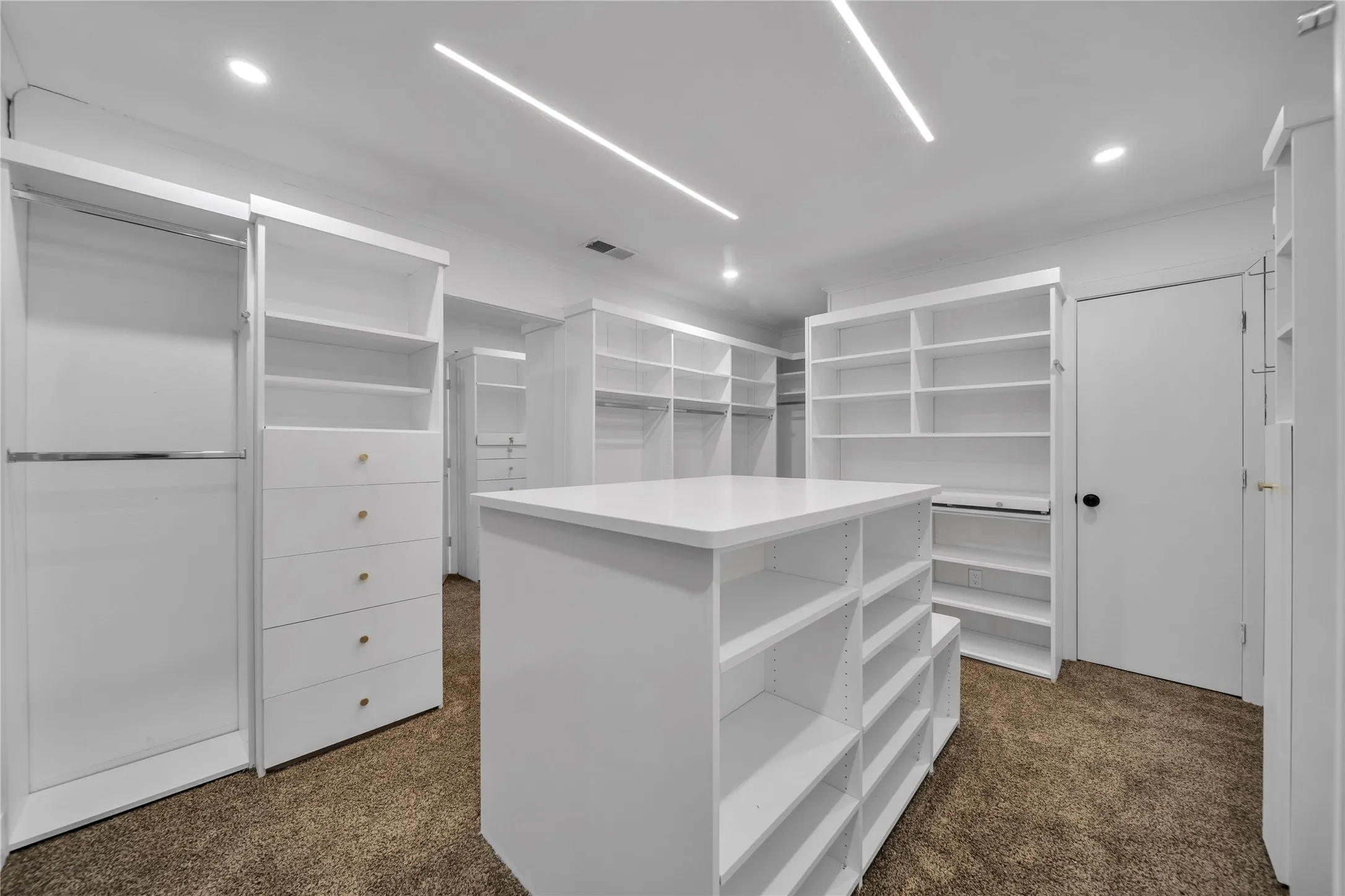 Spacious closet with dark colored carpet