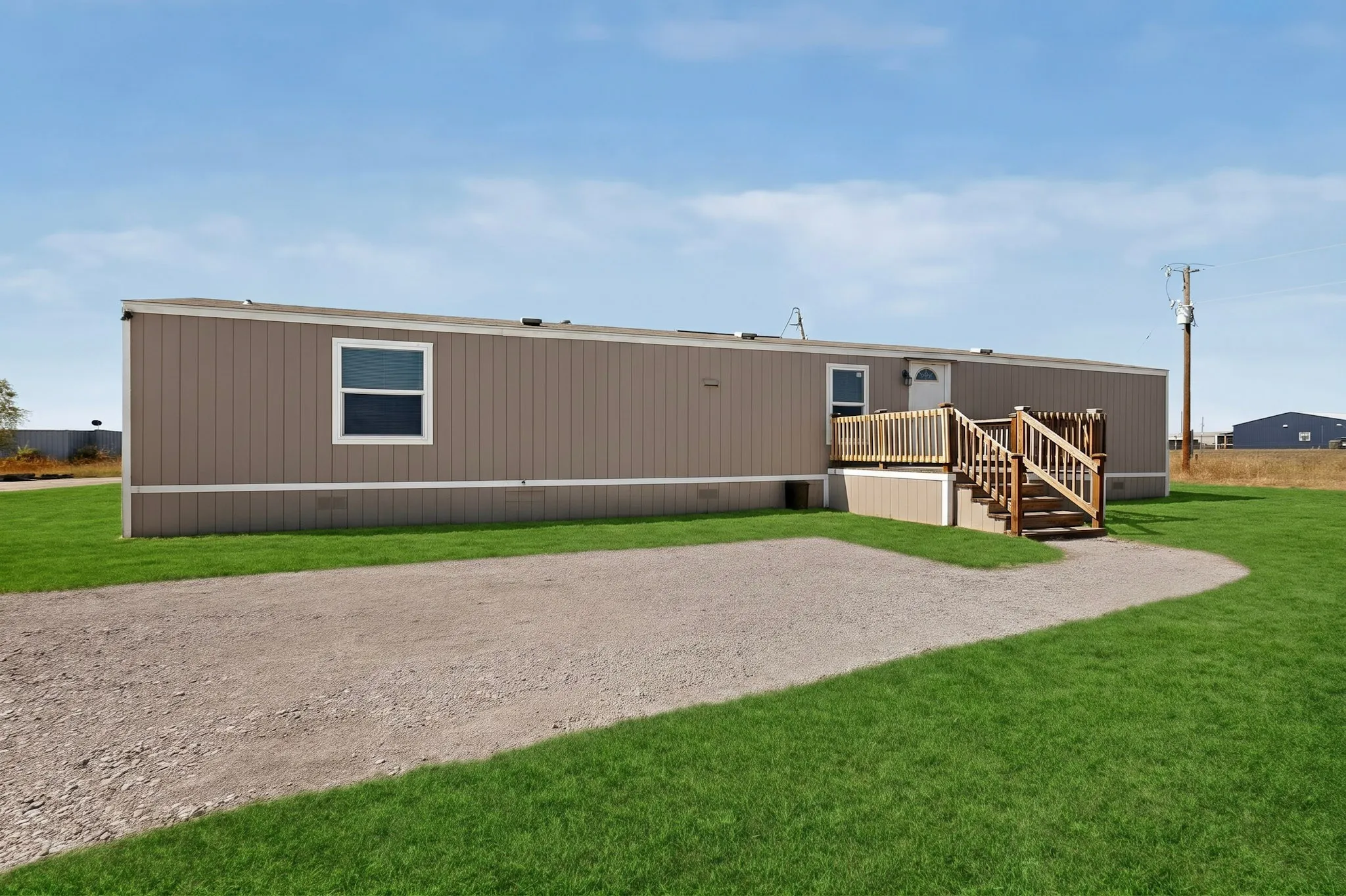 Single-story property with light brown vertical siding and white trim