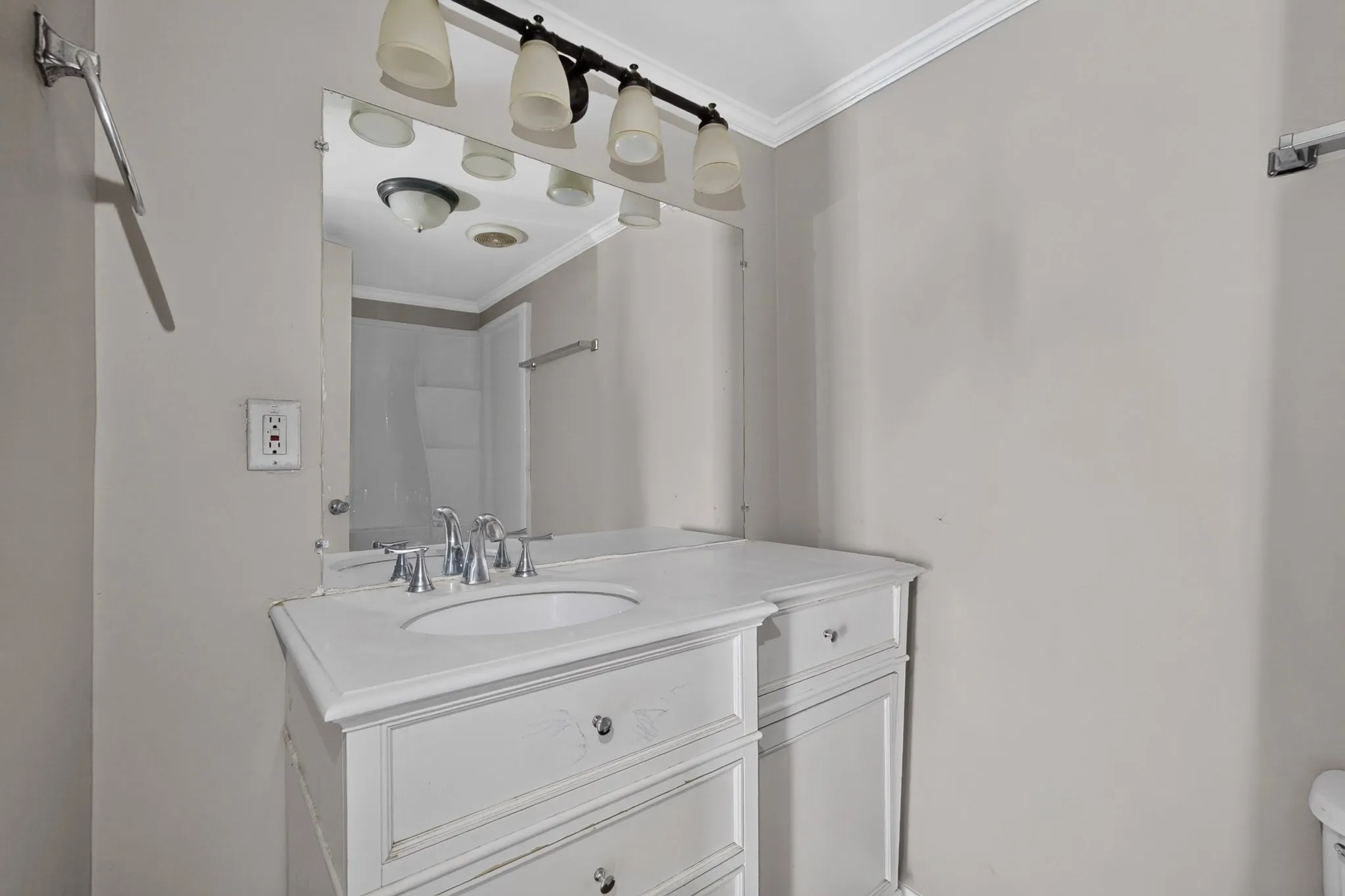 Elegant bathroom vanity featuring a white finish with dual drawers, white porcelain sink with chrome faucet fixtures, and quartz countertop