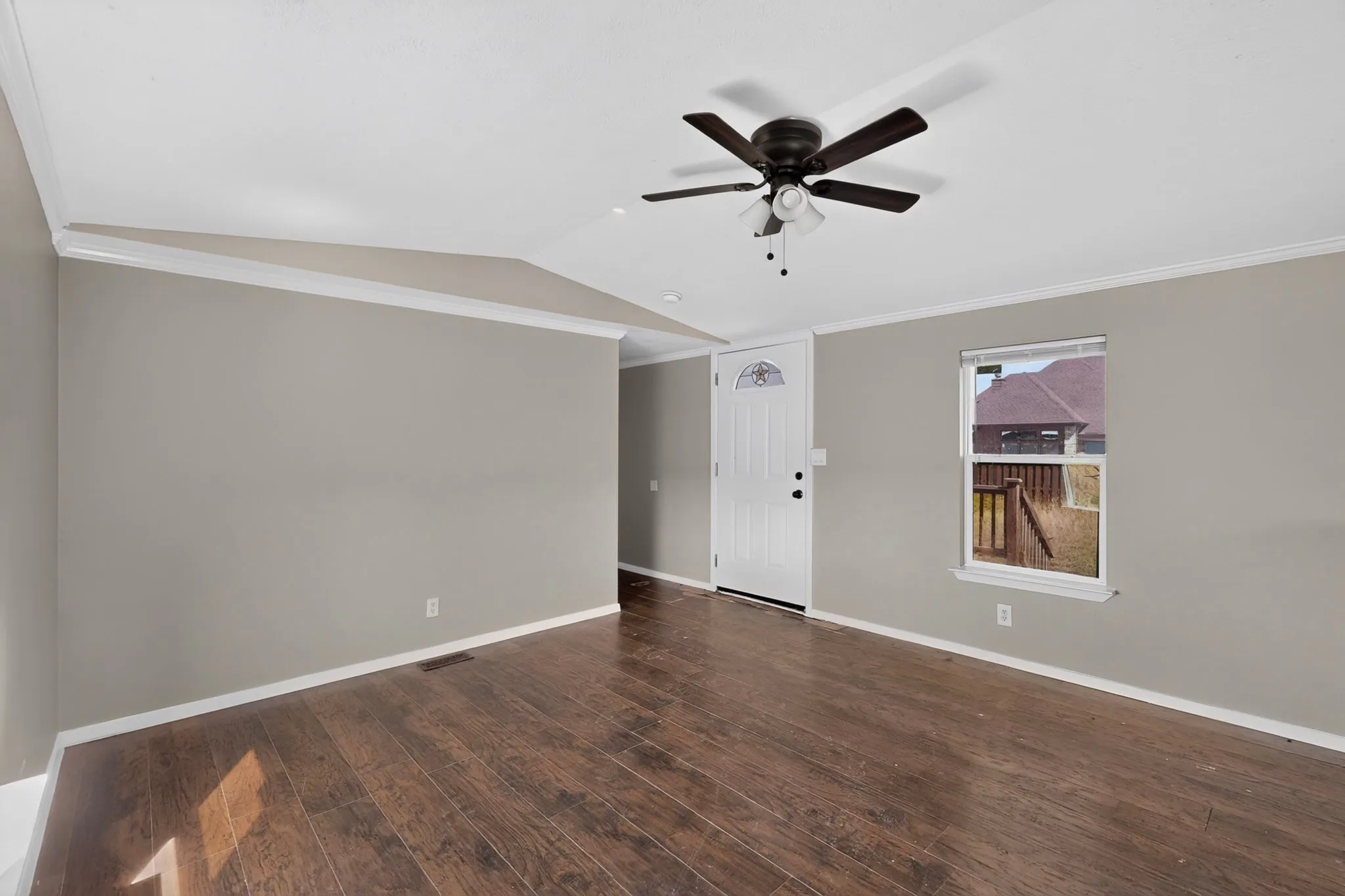Wood-finish flooring, neutral wall tones, crown molding, white trim, and a ceiling fan with integrated lighting