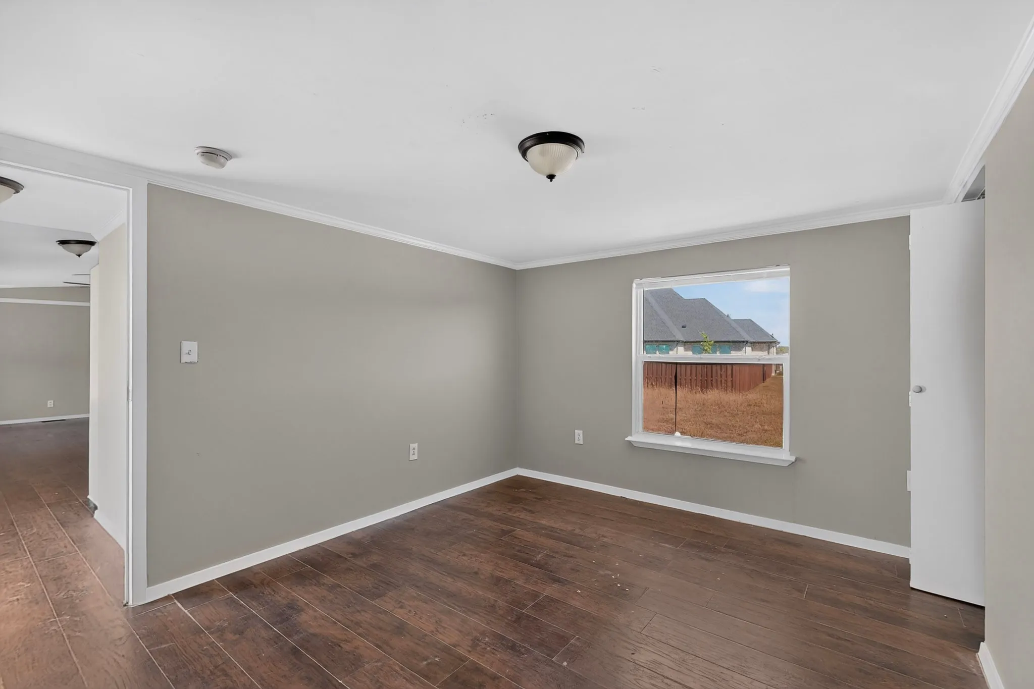 Wood-finish flooring, neutral wall tones, white trim, and a ceiling-mounted light fixture