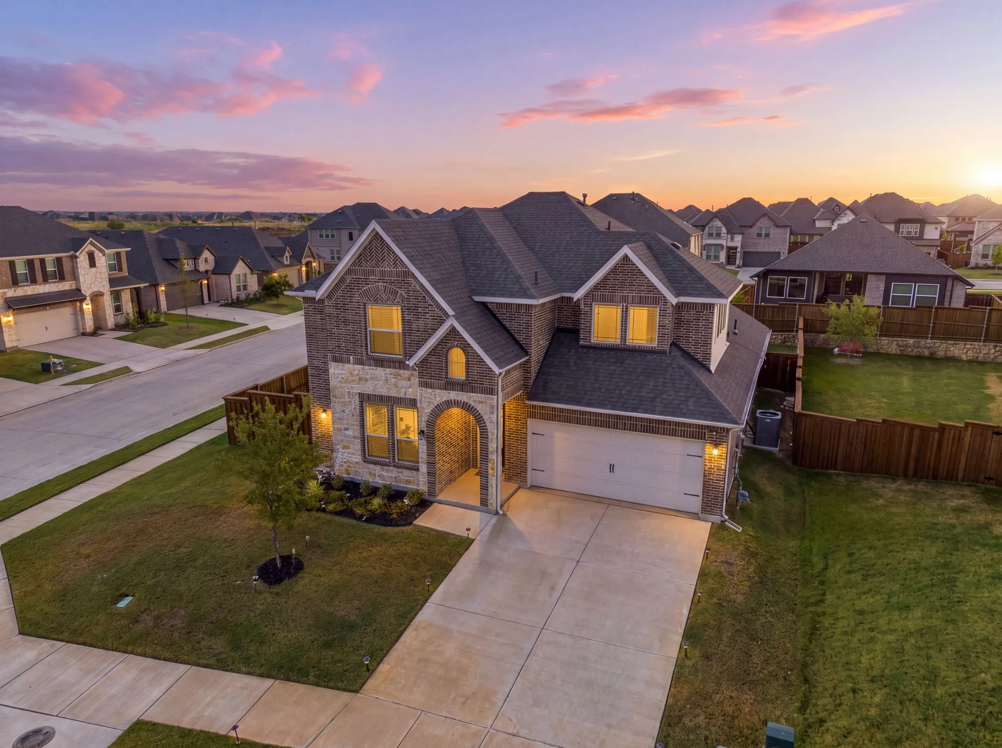 Elegant two-story residence featuring a stone and brick exterior with peaked rooflines and multiple gabled sections