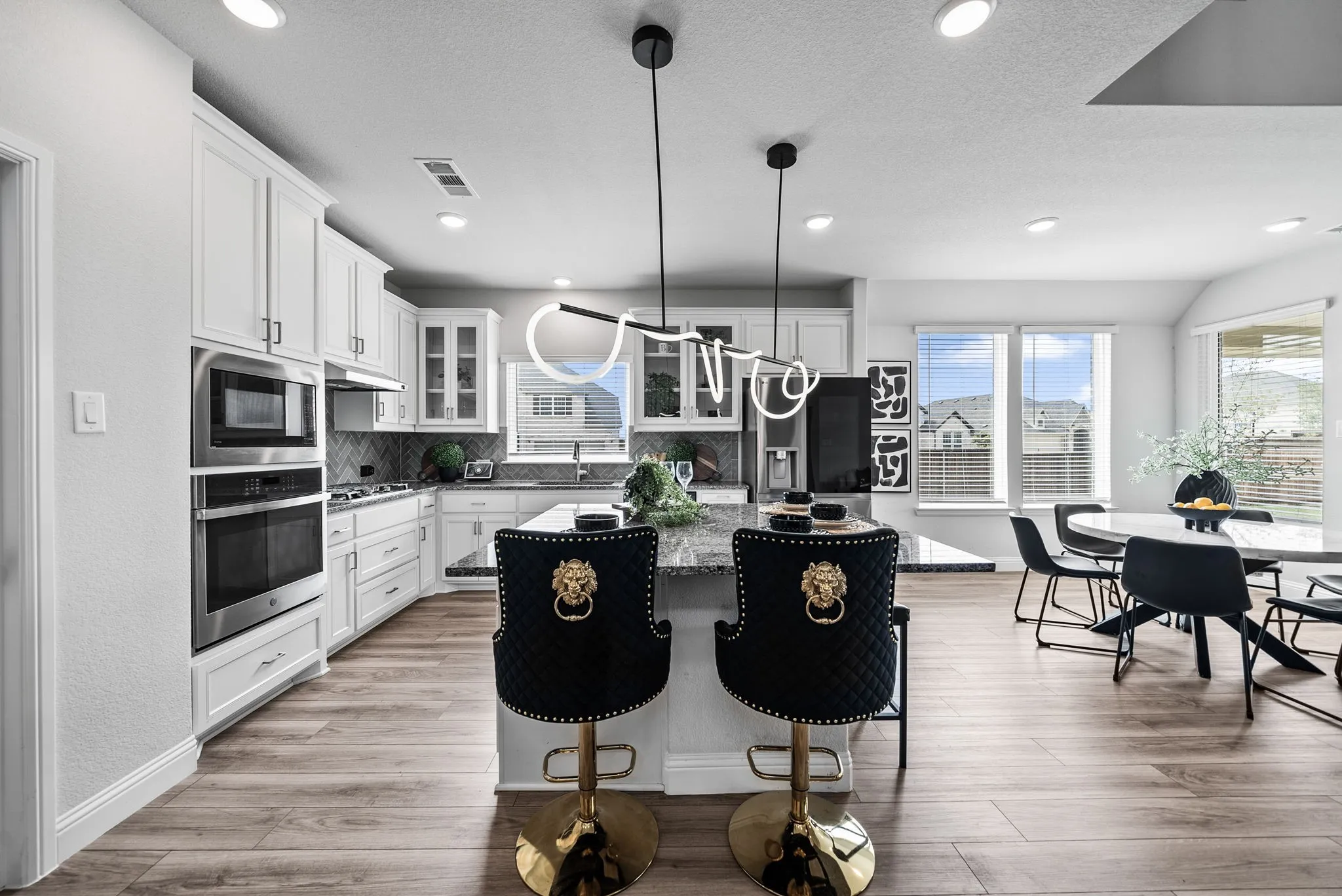 Gourmet kitchen with stainless steel appliances, white cabinetry, and granite countertops