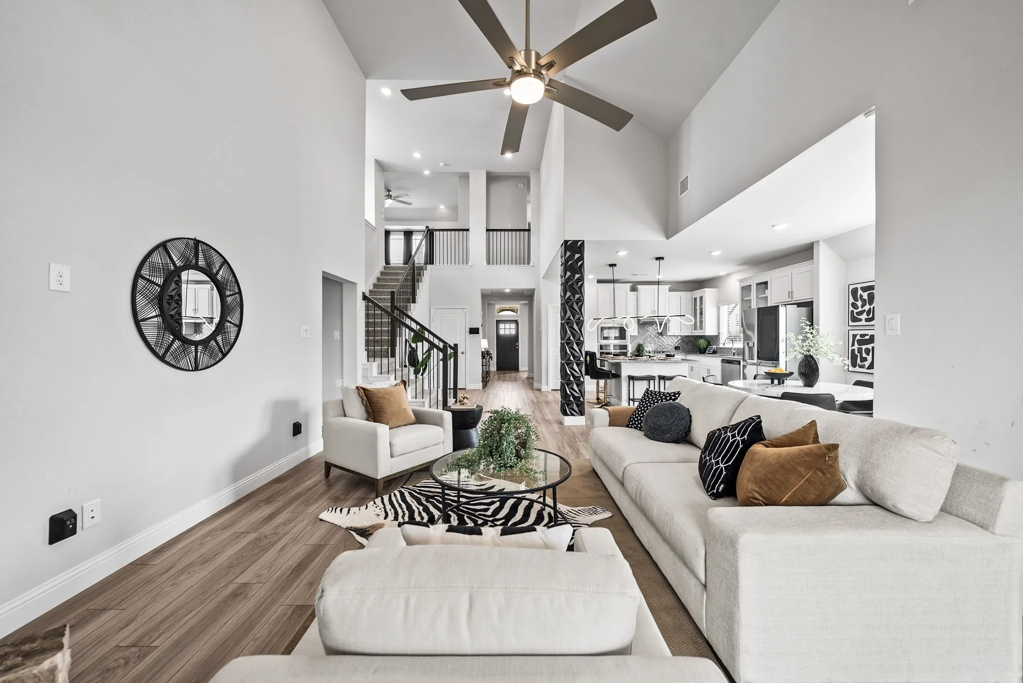Spacious living area featuring vaulted ceilings, wood-finish flooring, and an open concept layout