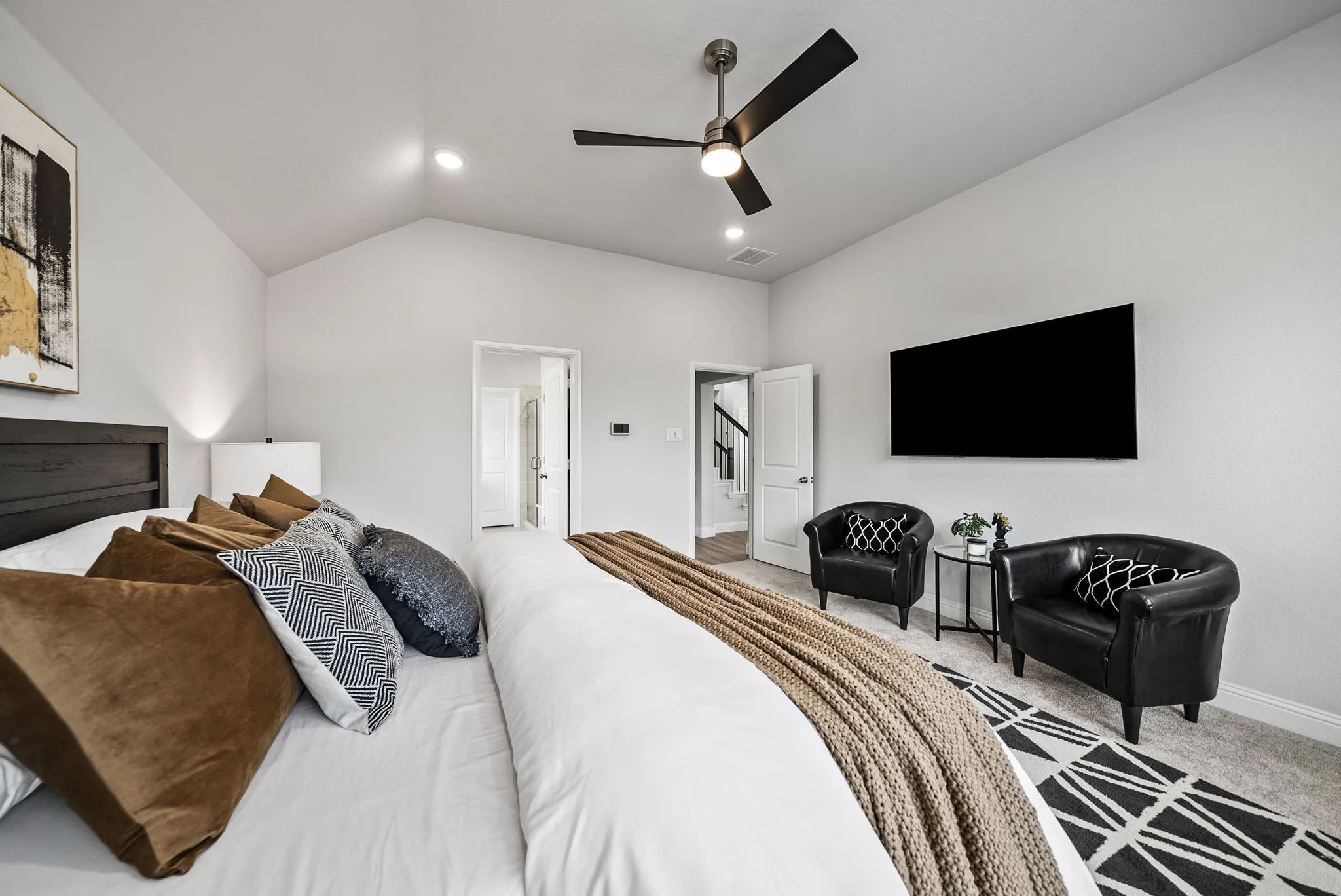 Vaulted ceiling with recessed lighting, ceiling fan with brushed nickel finish, mounted television, and light gray wall finish