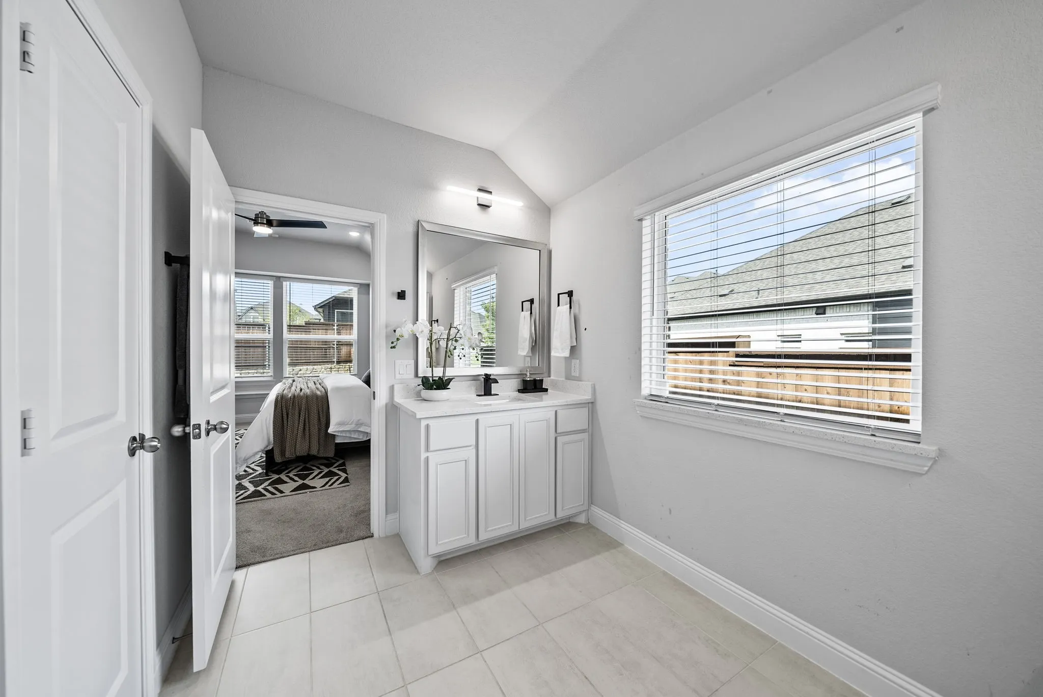 White vanity with storage, single basin, and framed mirror