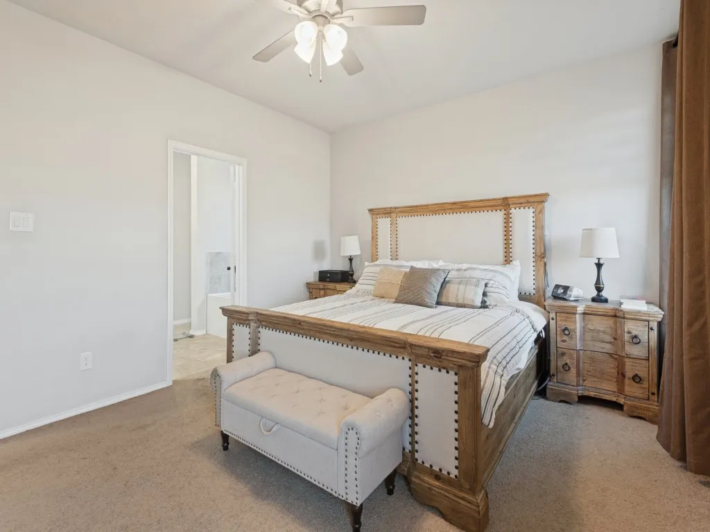 Recessed lighting with a ceiling fan, light-toned carpeting, and a doorway leading to an additional space with tile flooring
