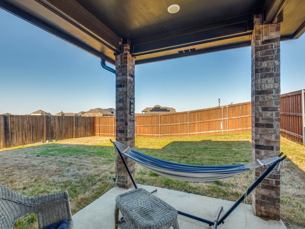 Covered patio with a concrete surface, brick columns, and a recessed light fixture