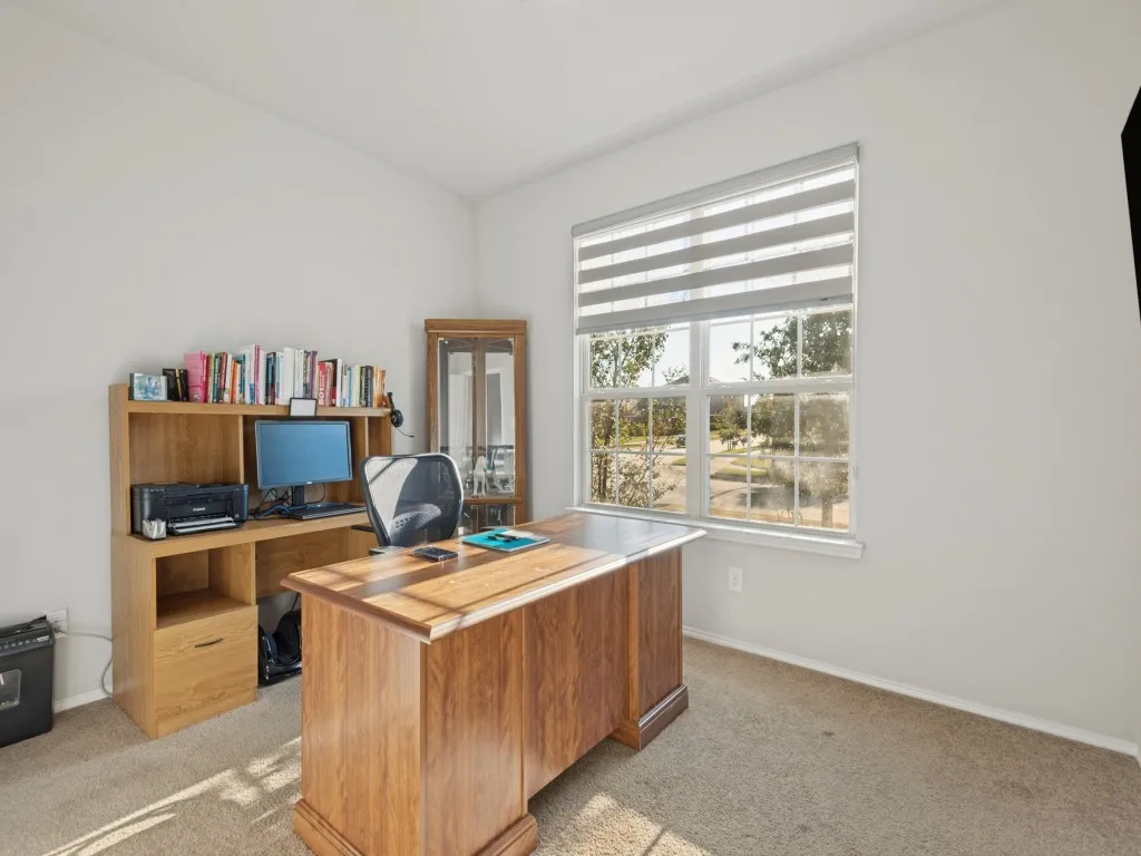 Brightly lit room featuring a large window with horizontal blinds