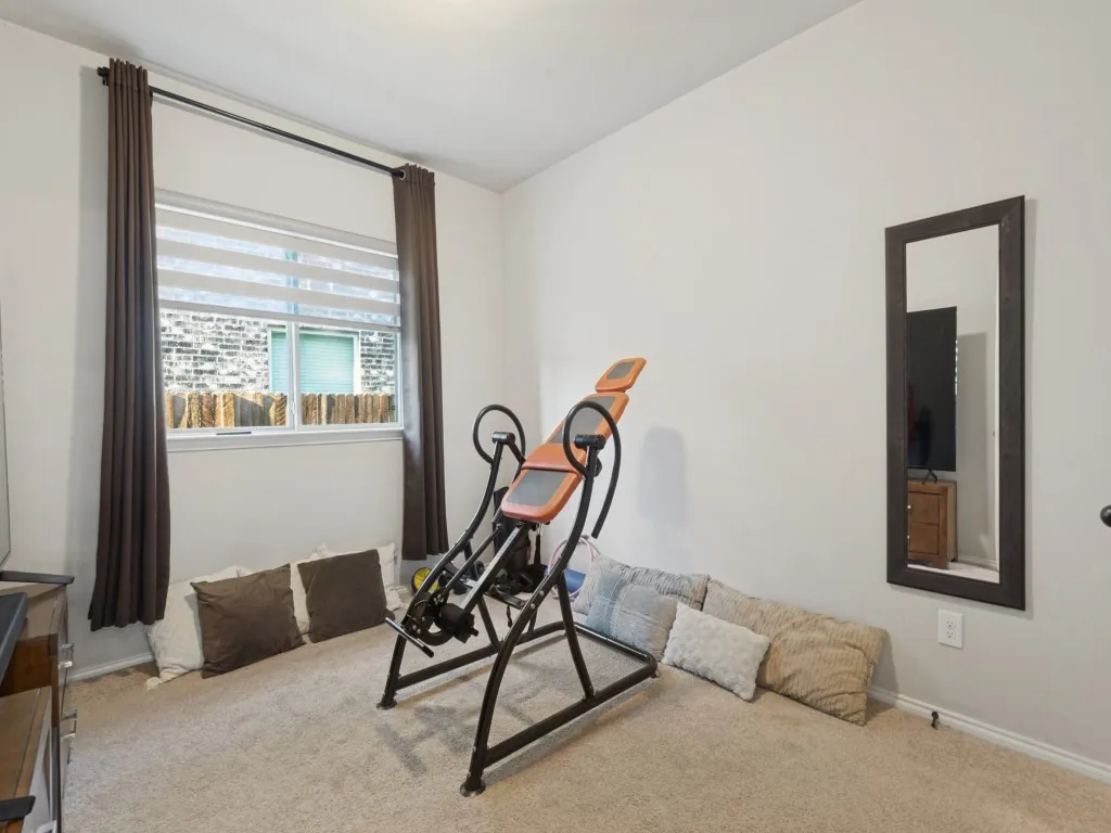 Neutral wall color, carpeted flooring, and a large window with blinds