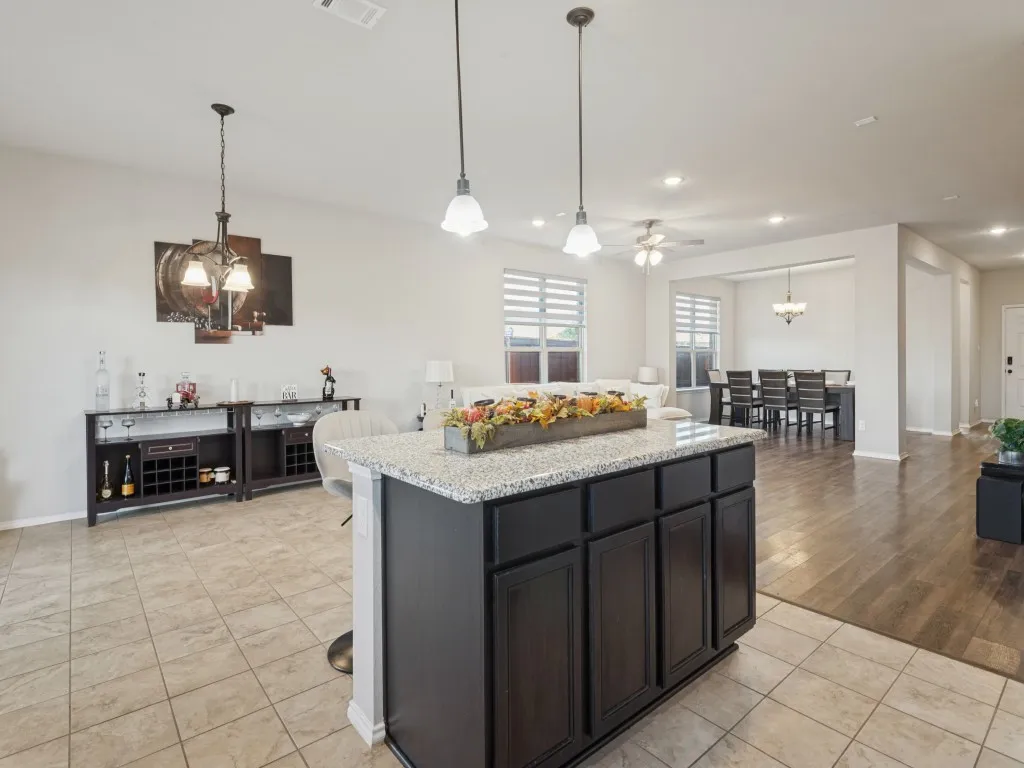 Kitchen island with dark cabinetry and a speckled countertop