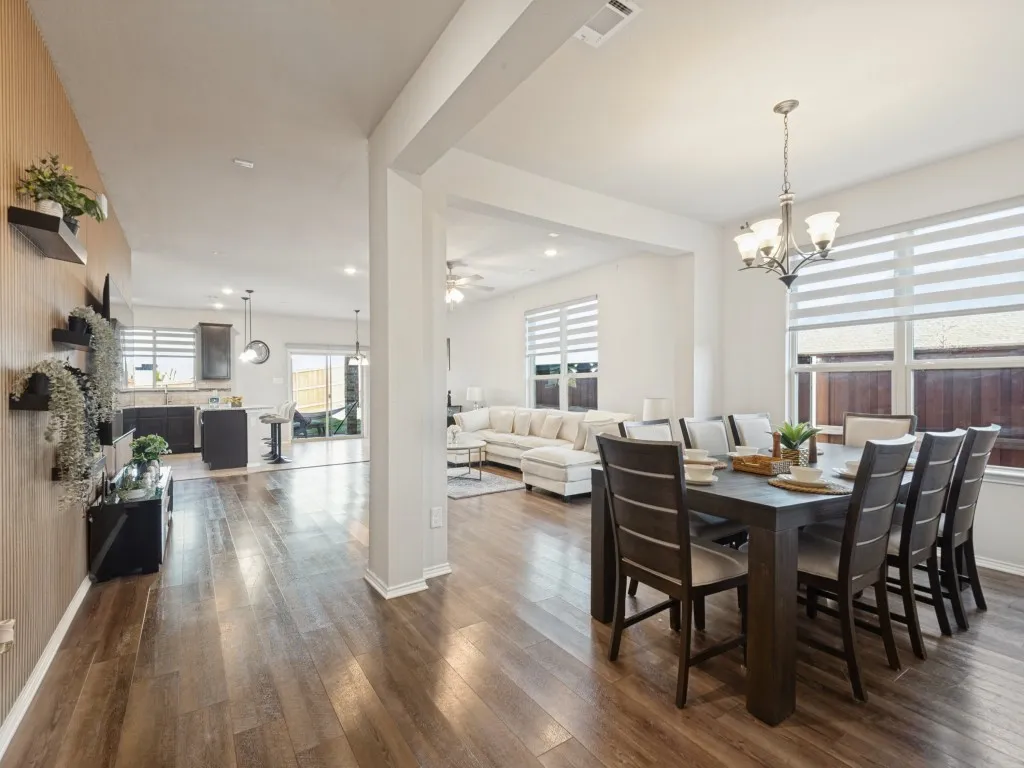Wood-finish flooring throughout, bright interior spaces, recessed ceiling lighting, and a modern chandelier
