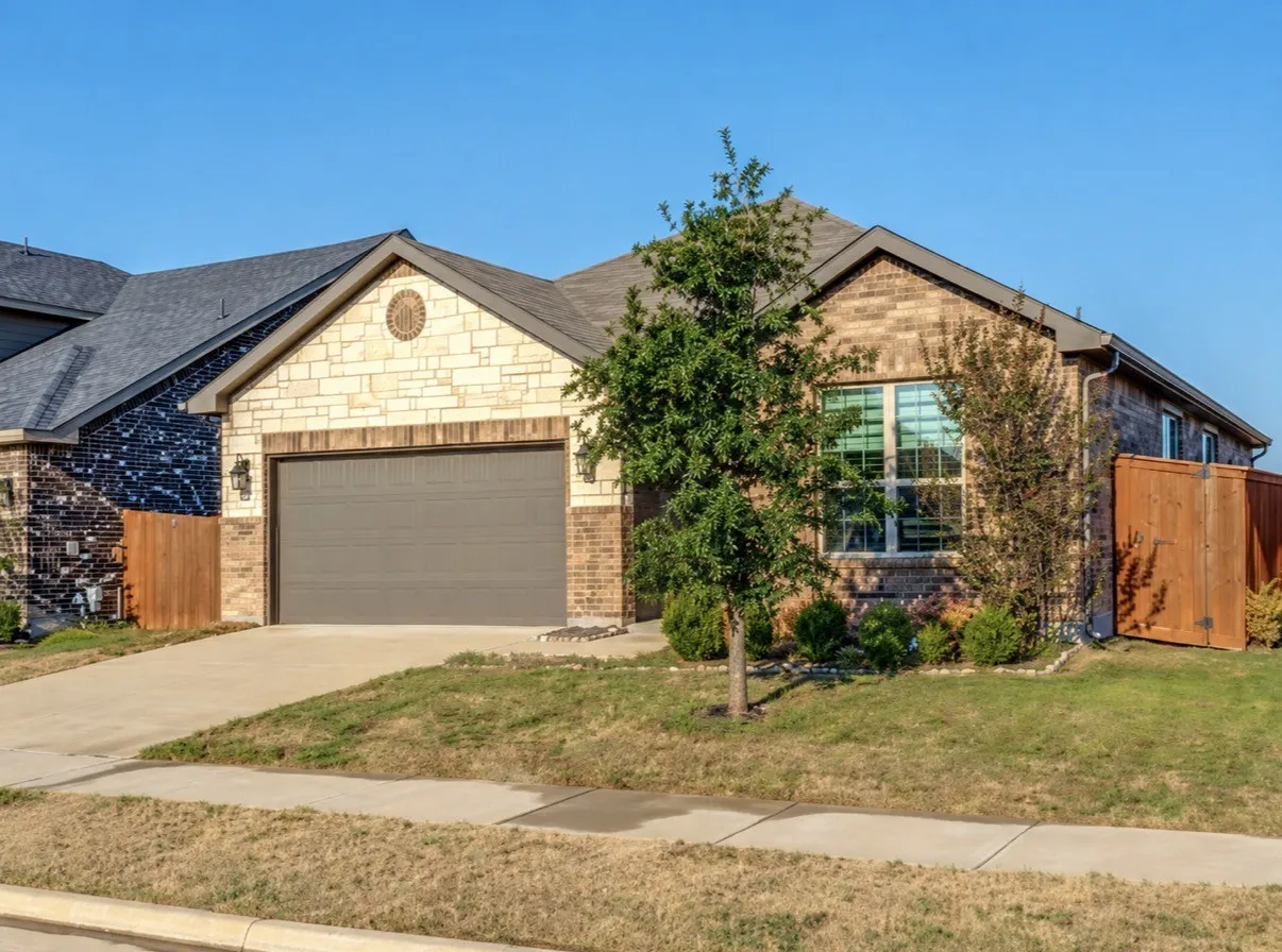 Brick and stone exterior with a gabled roofline and an attached garage