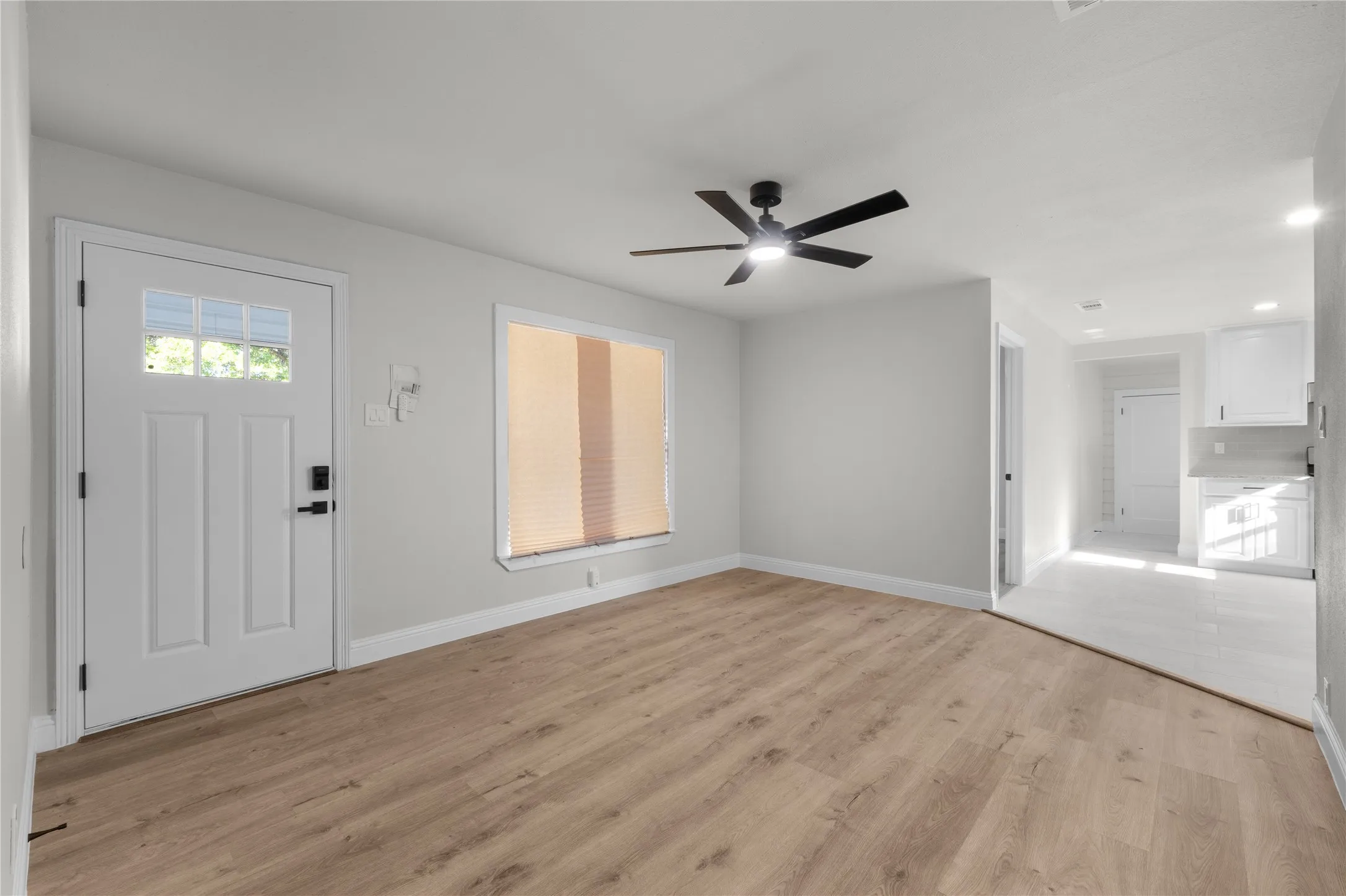 Wood-finish flooring, recessed lighting, and a contemporary ceiling fan