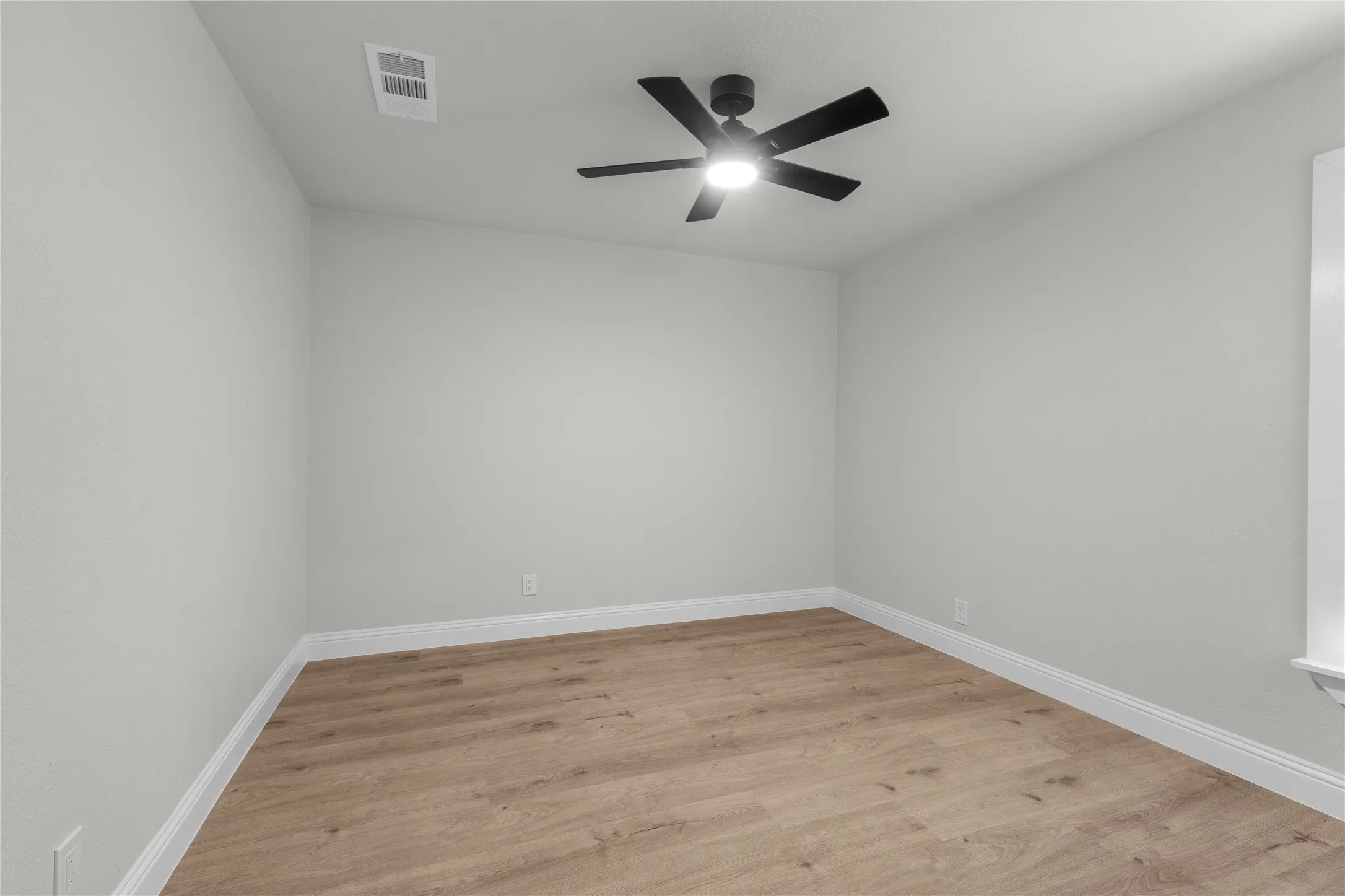 Recessed ceiling fan with light fixture, wood-finish flooring, light neutral wall color, and white trim