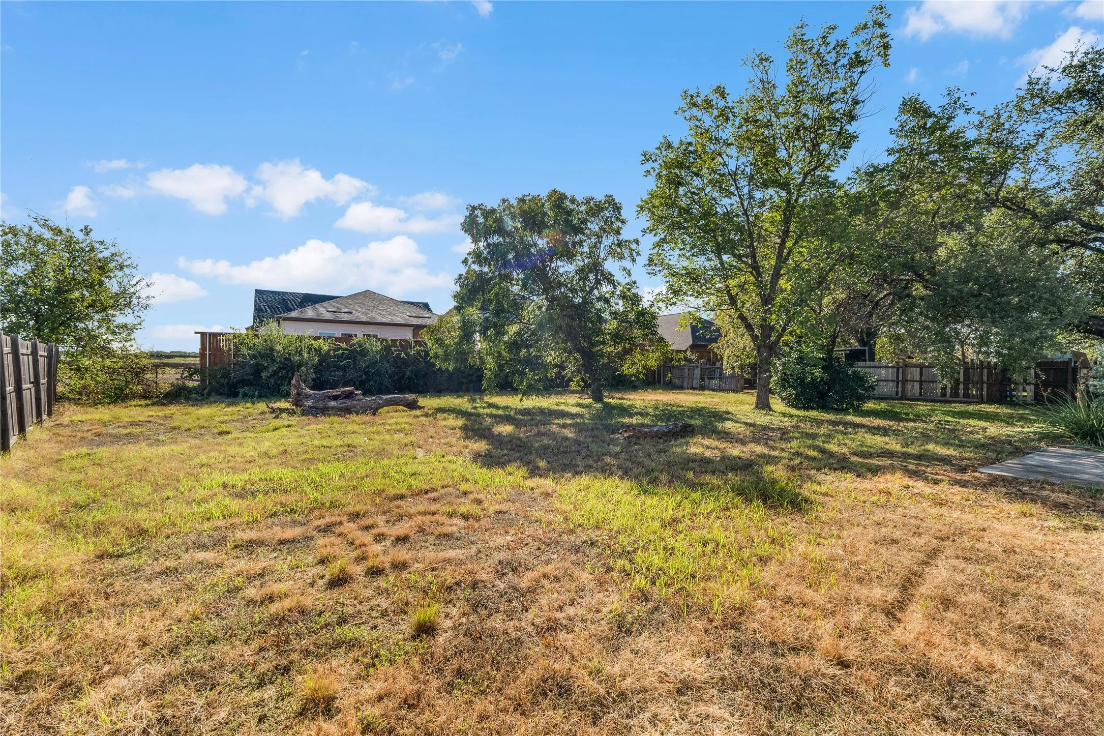Expansive lot featuring mature trees and perimeter fencing