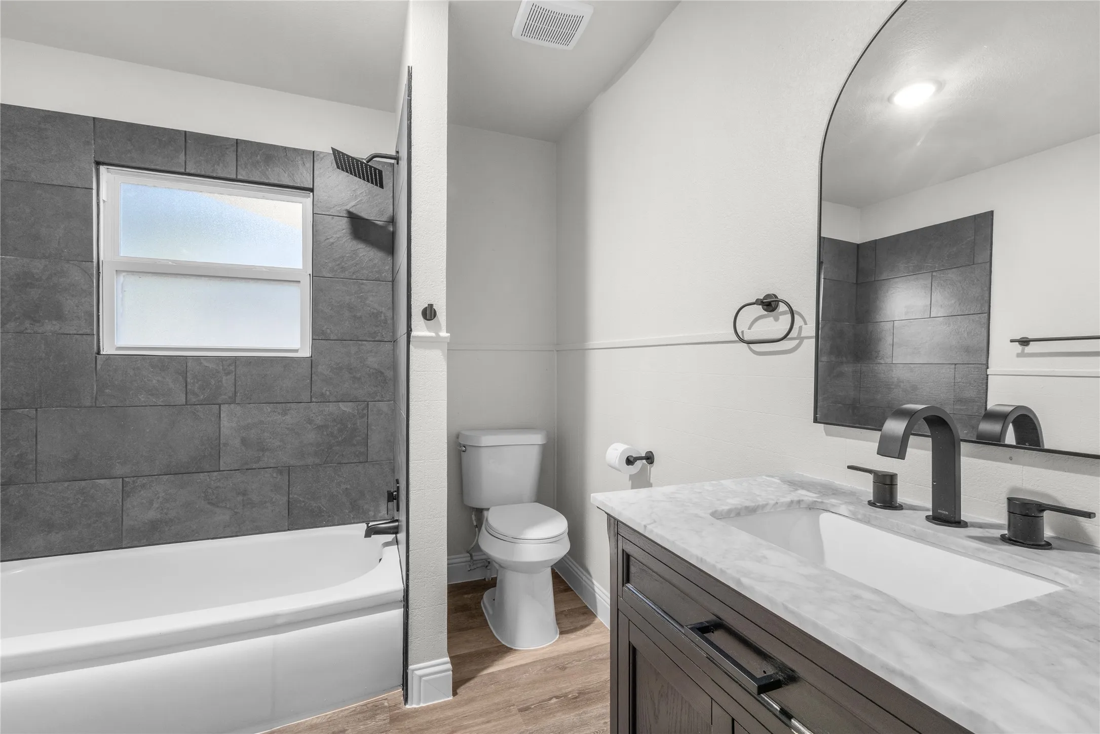 Vanity with a light-toned stone countertop and undermount sink