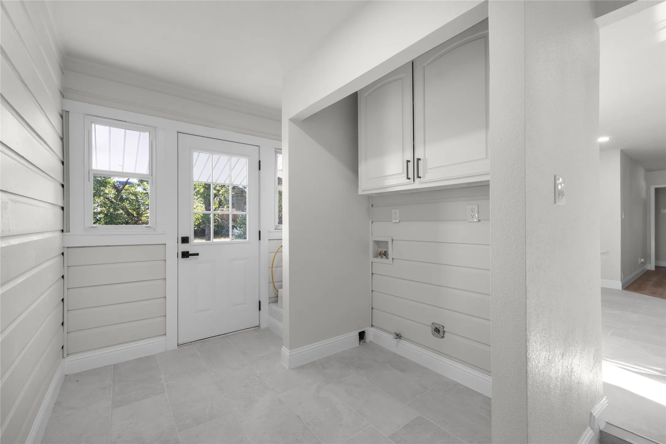 Entryway with a glass-paneled door, sidelight windows, and light tile flooring