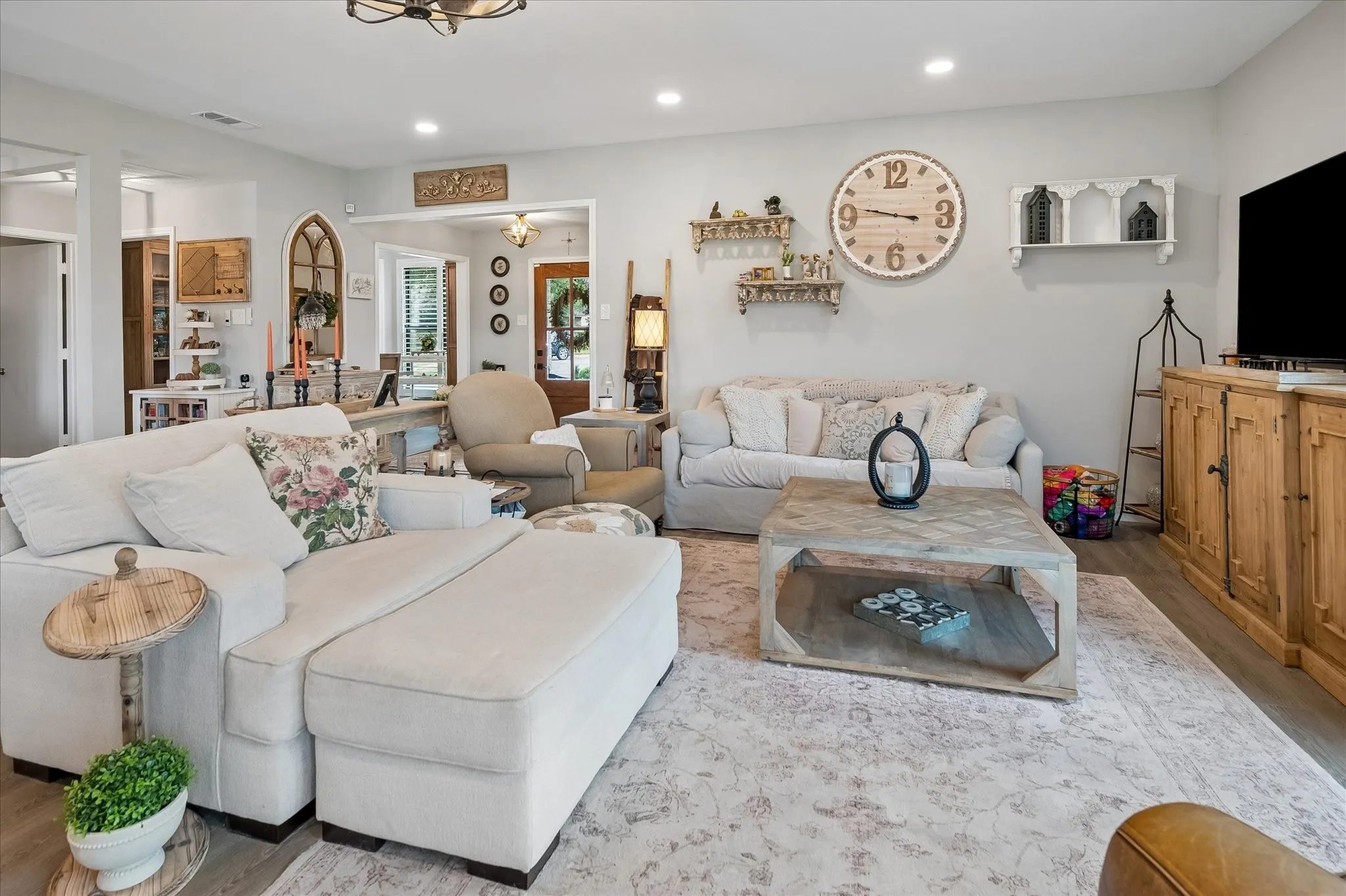 Living room featuring wood-finish flooring, recessed lighting, and an arched decorative wall niche