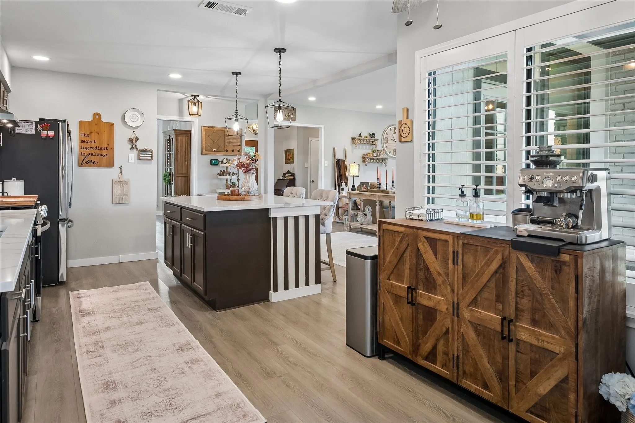 Kitchen featuring a central island with a stone countertop, dark-finish cabinetry, recessed lighting, and wood-finish flooring