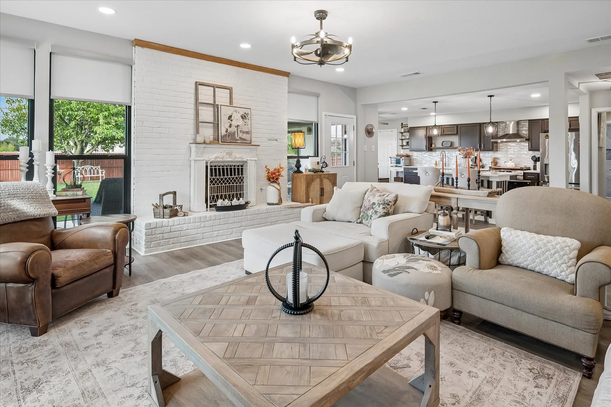 Living area featuring a floor-to-ceiling white painted brick fireplace, wood-finish flooring, recessed lighting, and a drum-style ceiling fan