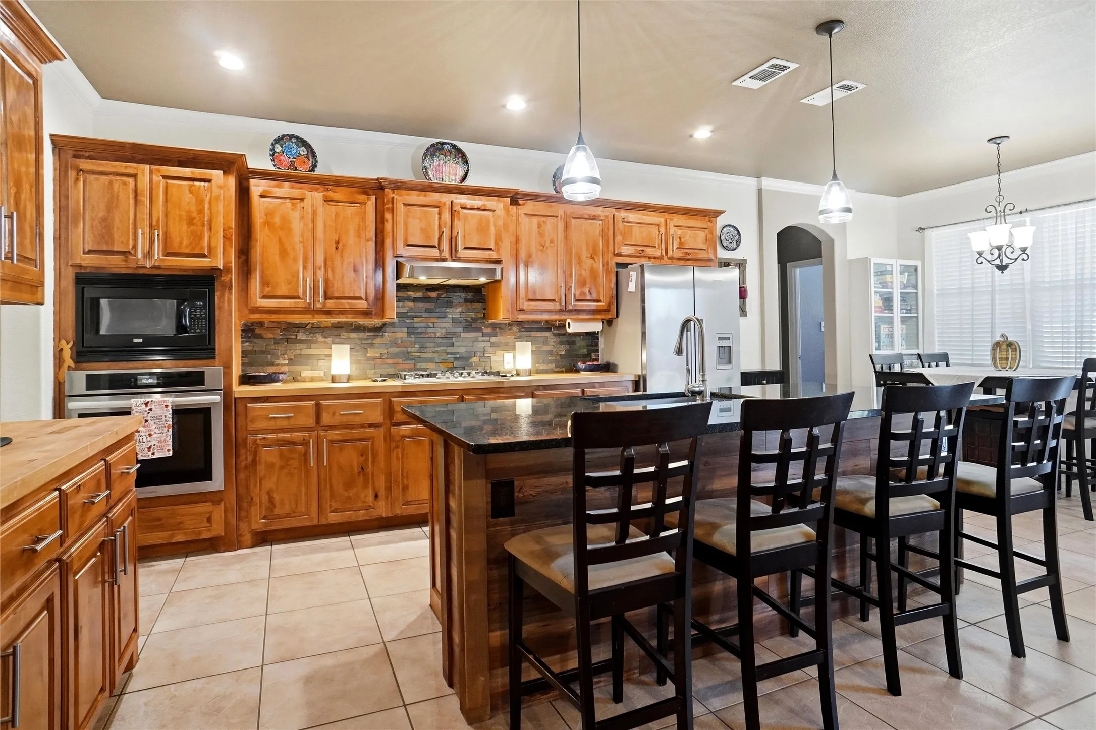 Spacious kitchen, gas cooktop, granite and butcherblock countertops, with large breakfast area to the right.