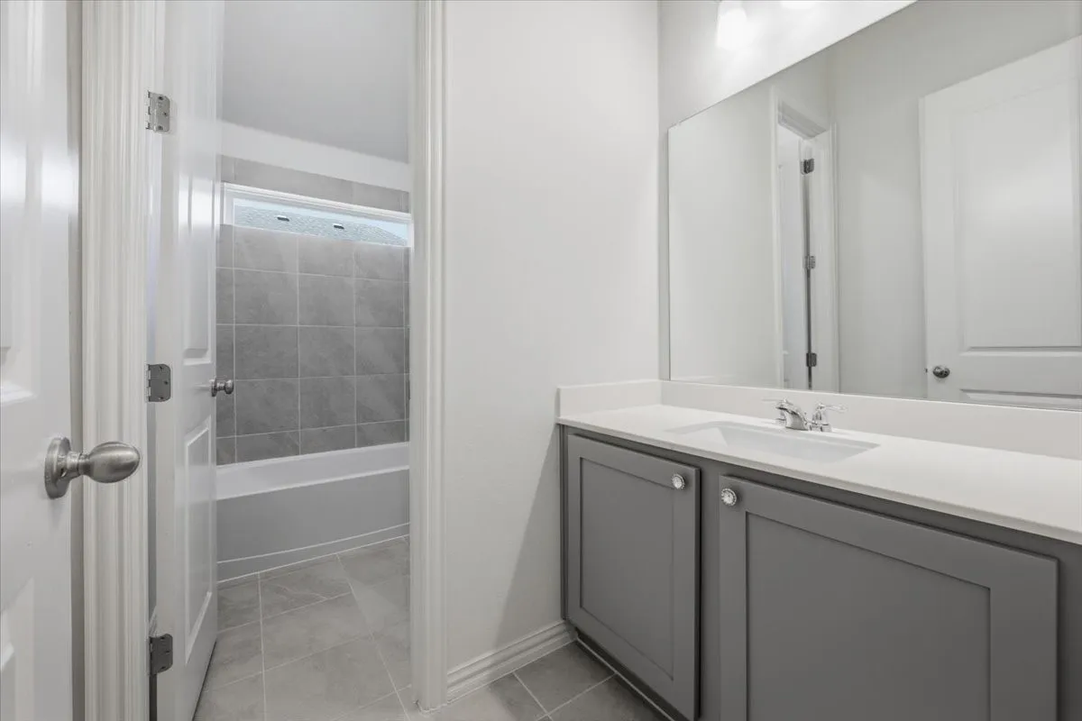 Dual vanity with white countertop, integrated sink, and gray cabinetry