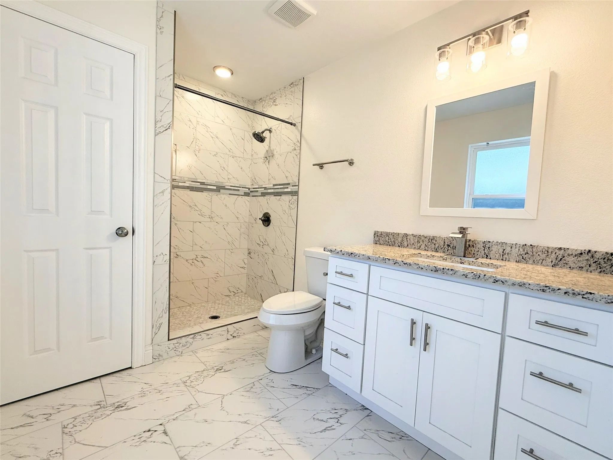 Shower enclosure with a glass door and decorative tile inlay