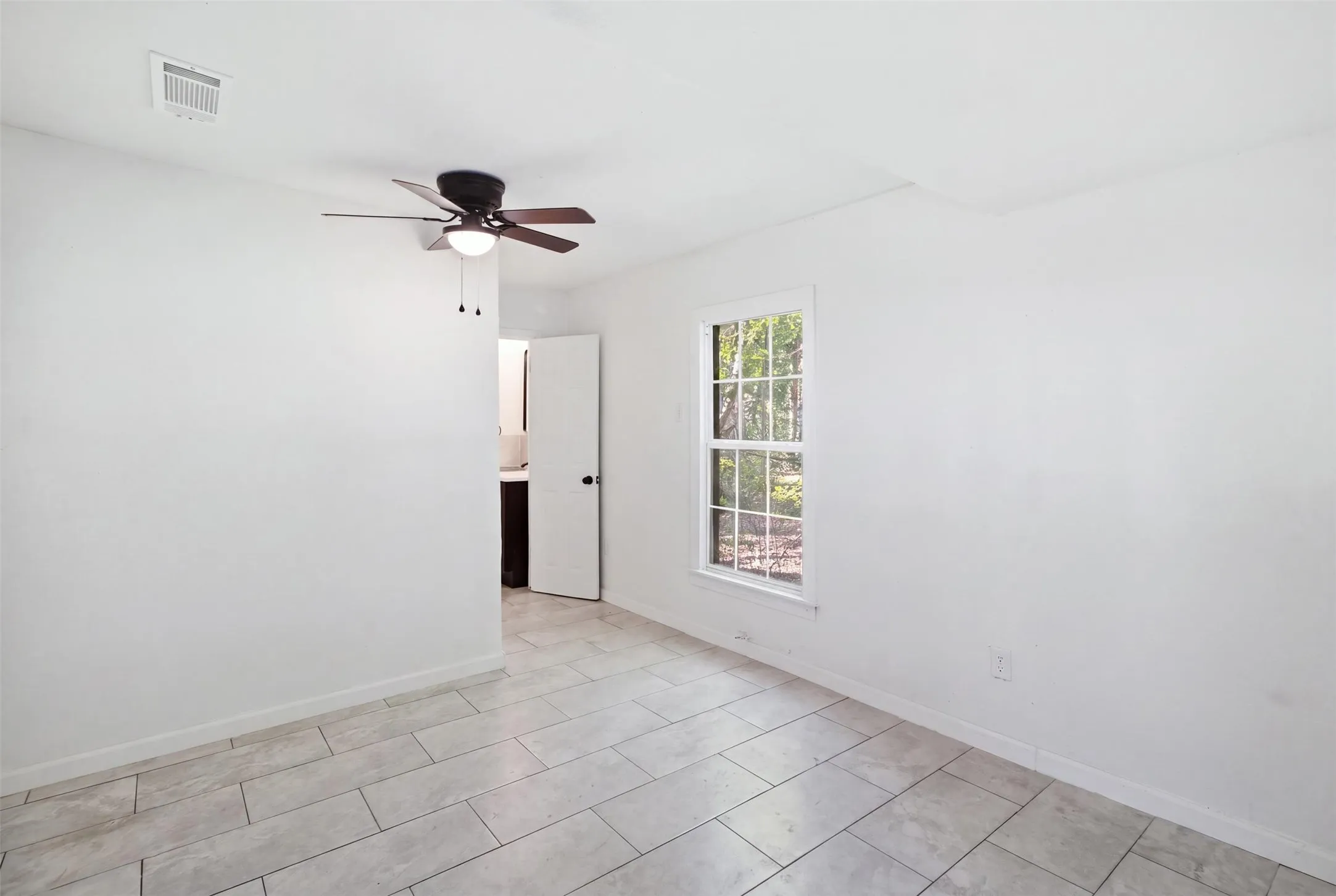 Tile flooring, ceiling fan with integrated lighting, and a single-pane window