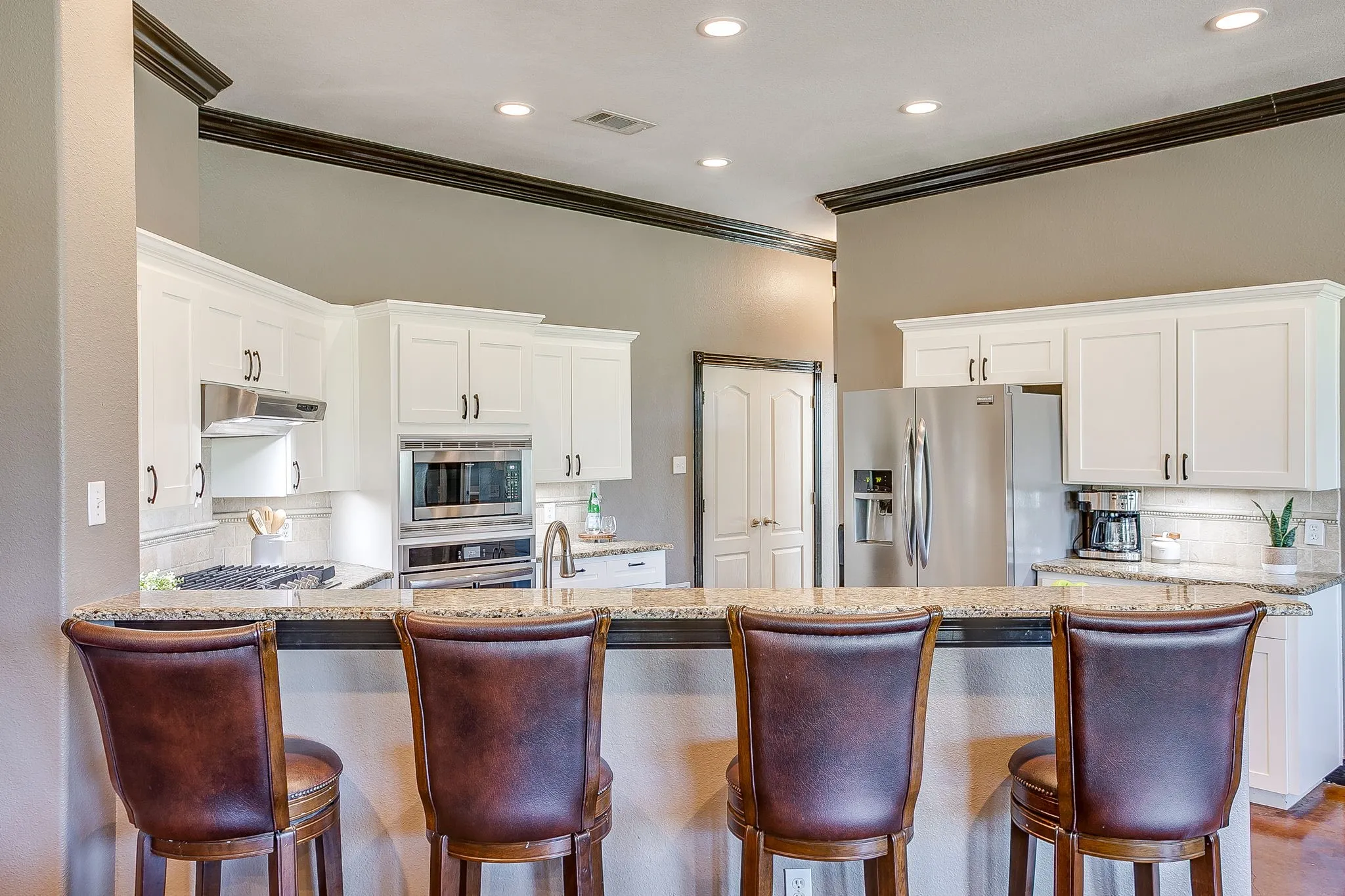 Kitchen featuring white cabinetry, stainless steel appliances, granite countertops, and recessed lighting