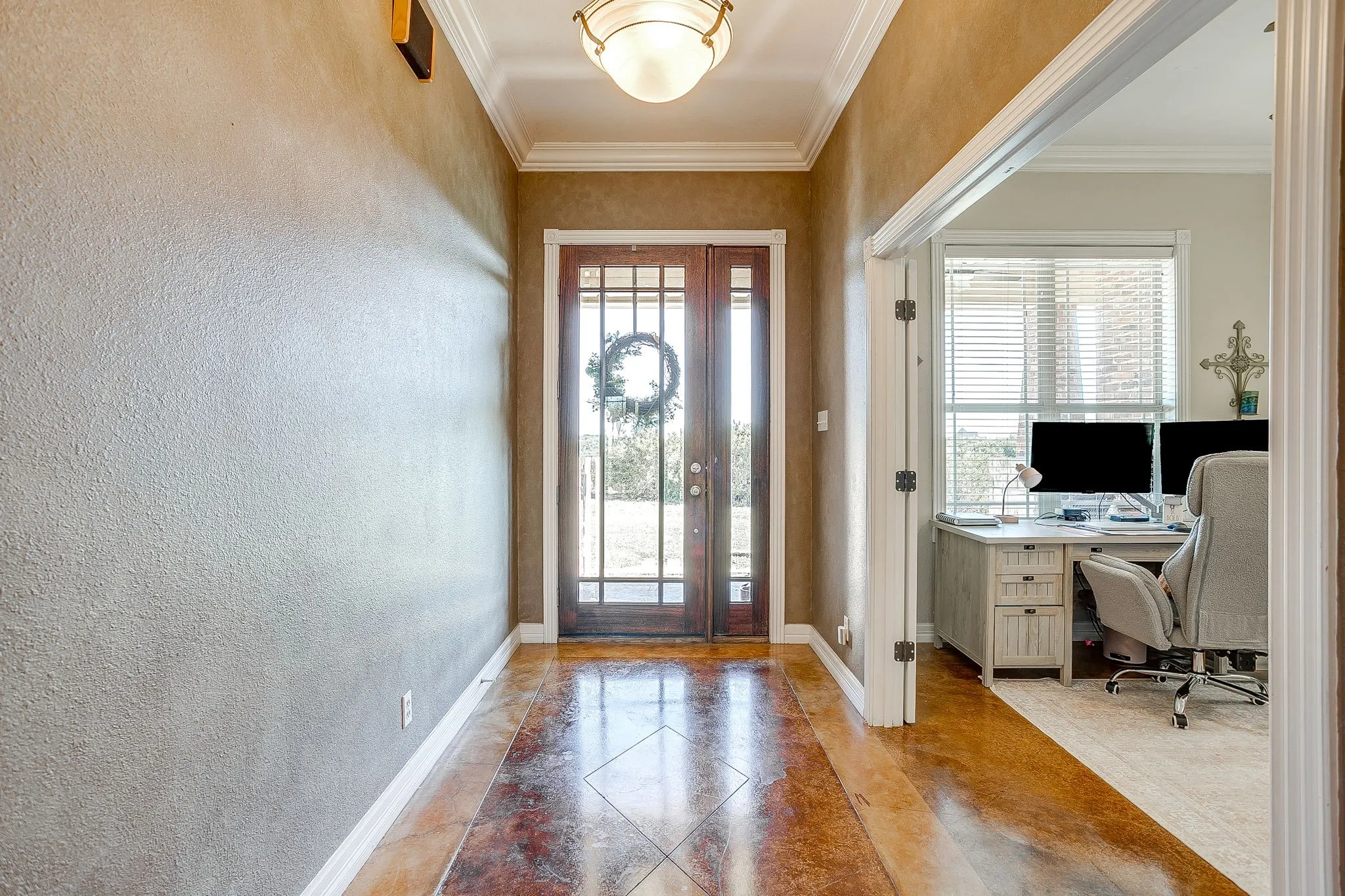 Architectural archway with crown molding, double entry doors with decorative glass, and a flush mount ceiling light