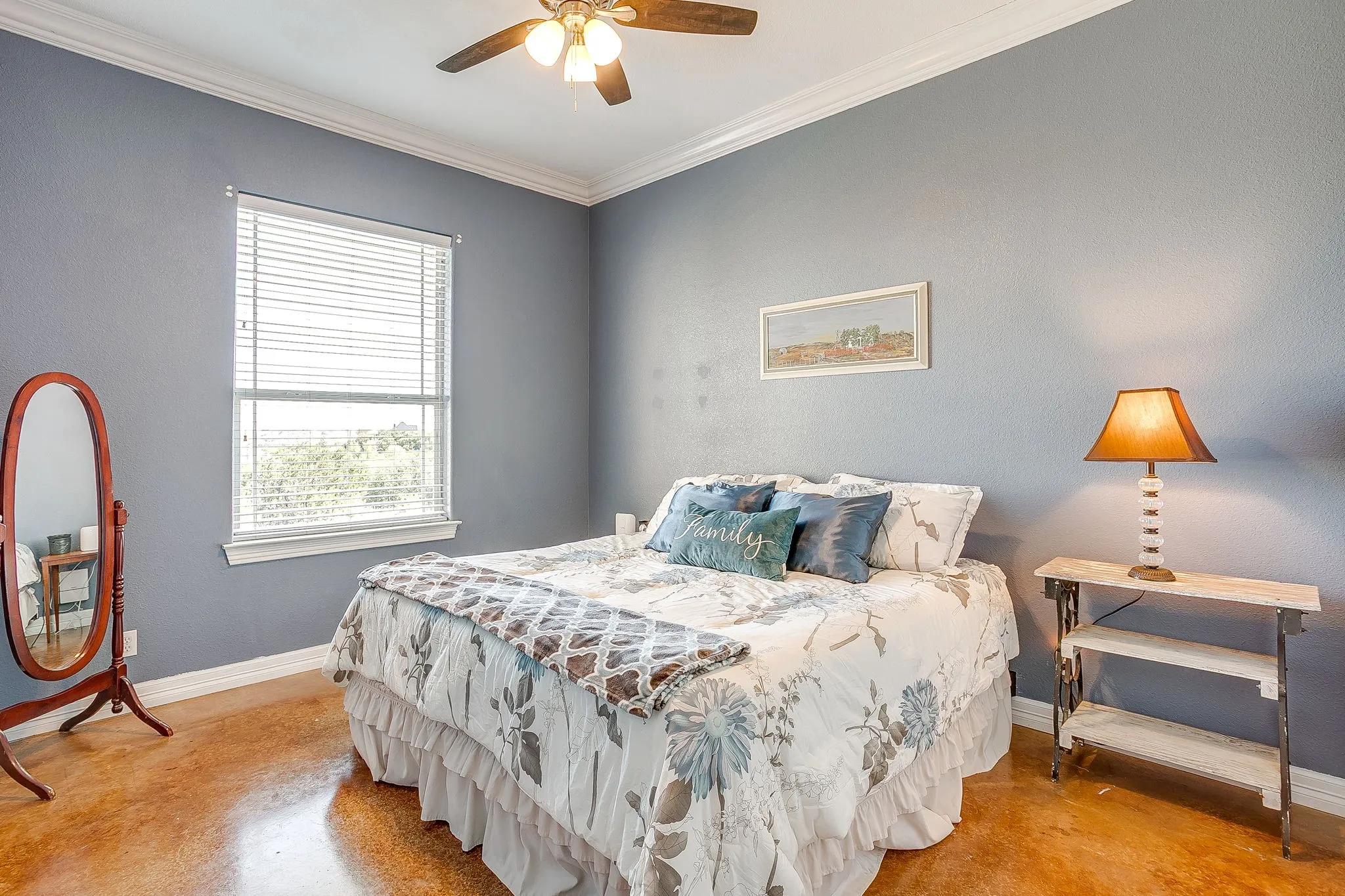 Recessed window with blinds, ceiling fan with integrated lighting, crown molding, and polished concrete flooring